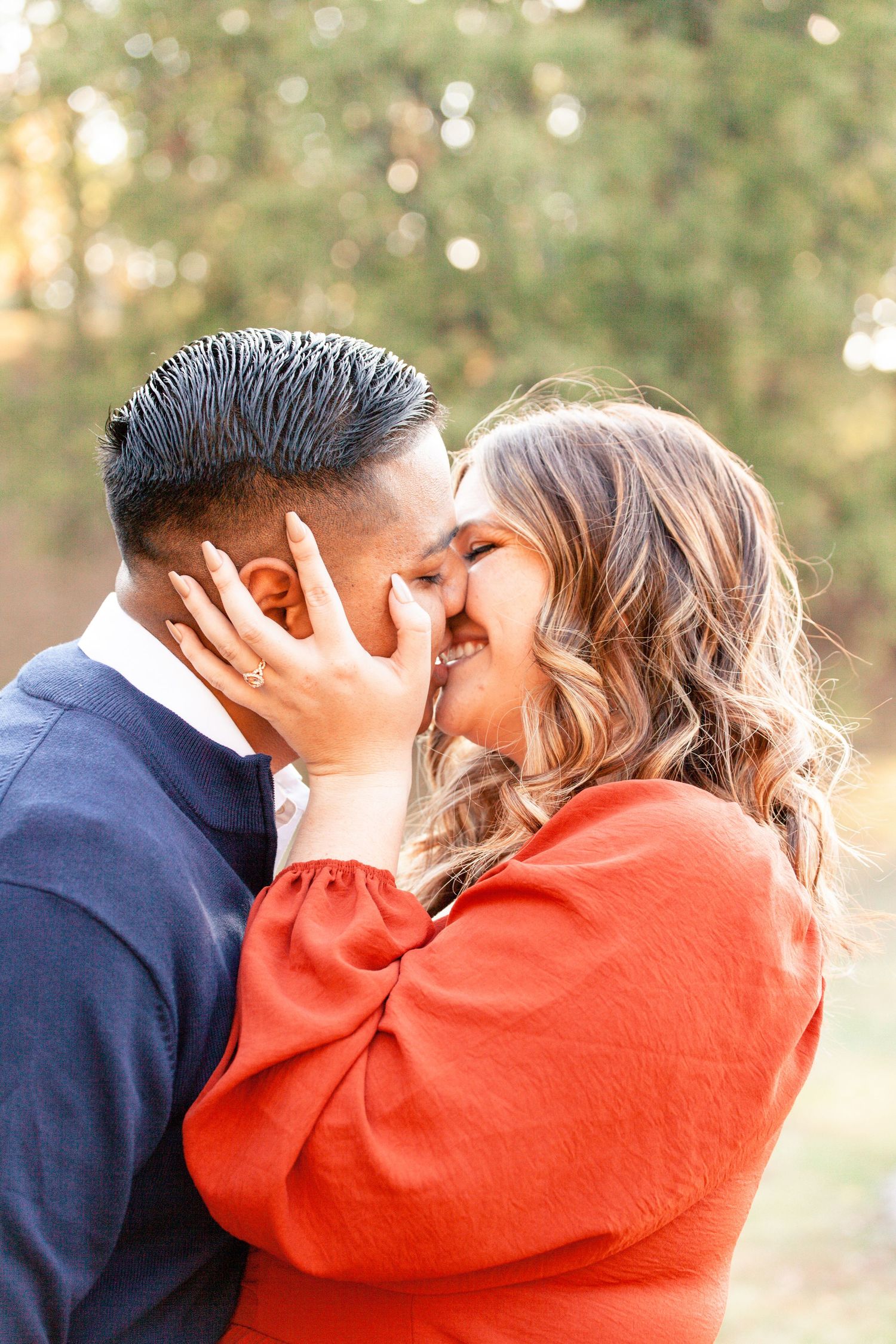 A romantic couple embraces and kisses in a series of sunset photos with warm bokeh lighting.