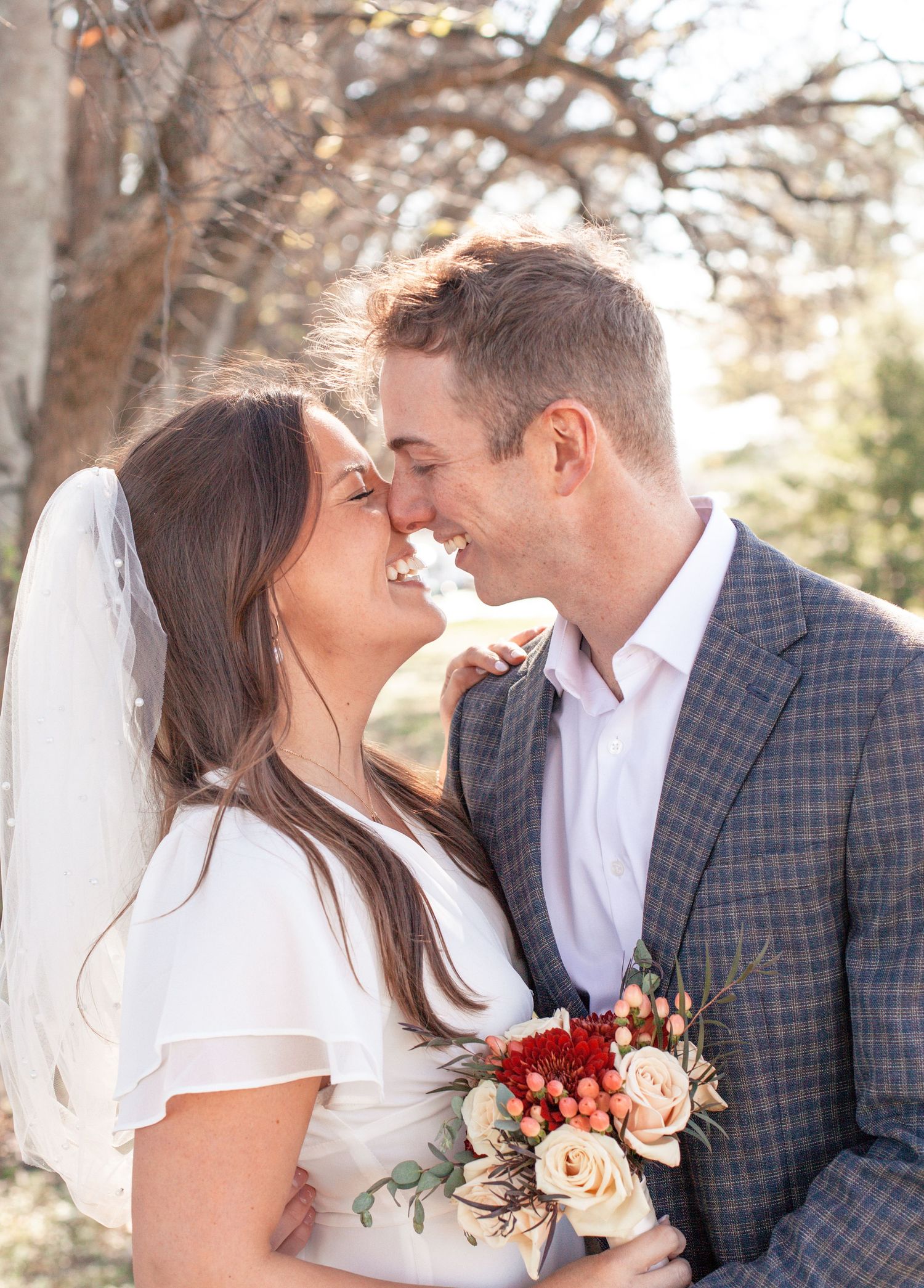 A romantic outdoor wedding portrait with a couple sharing an intimate moment.