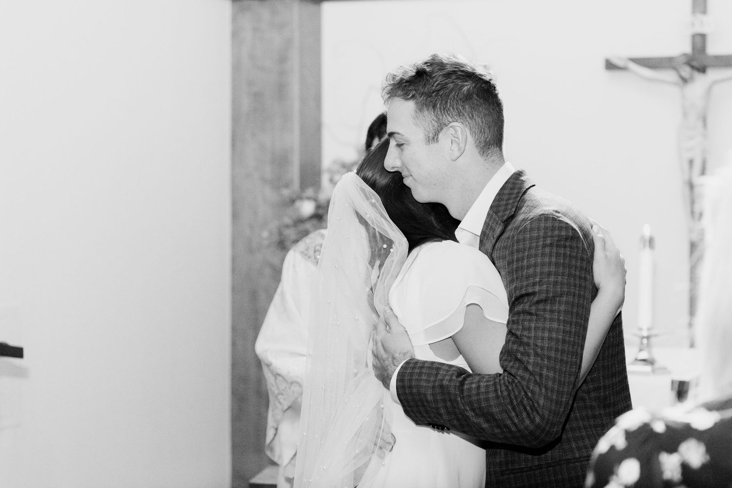 An intimate black and white wedding ceremony moment in a church.