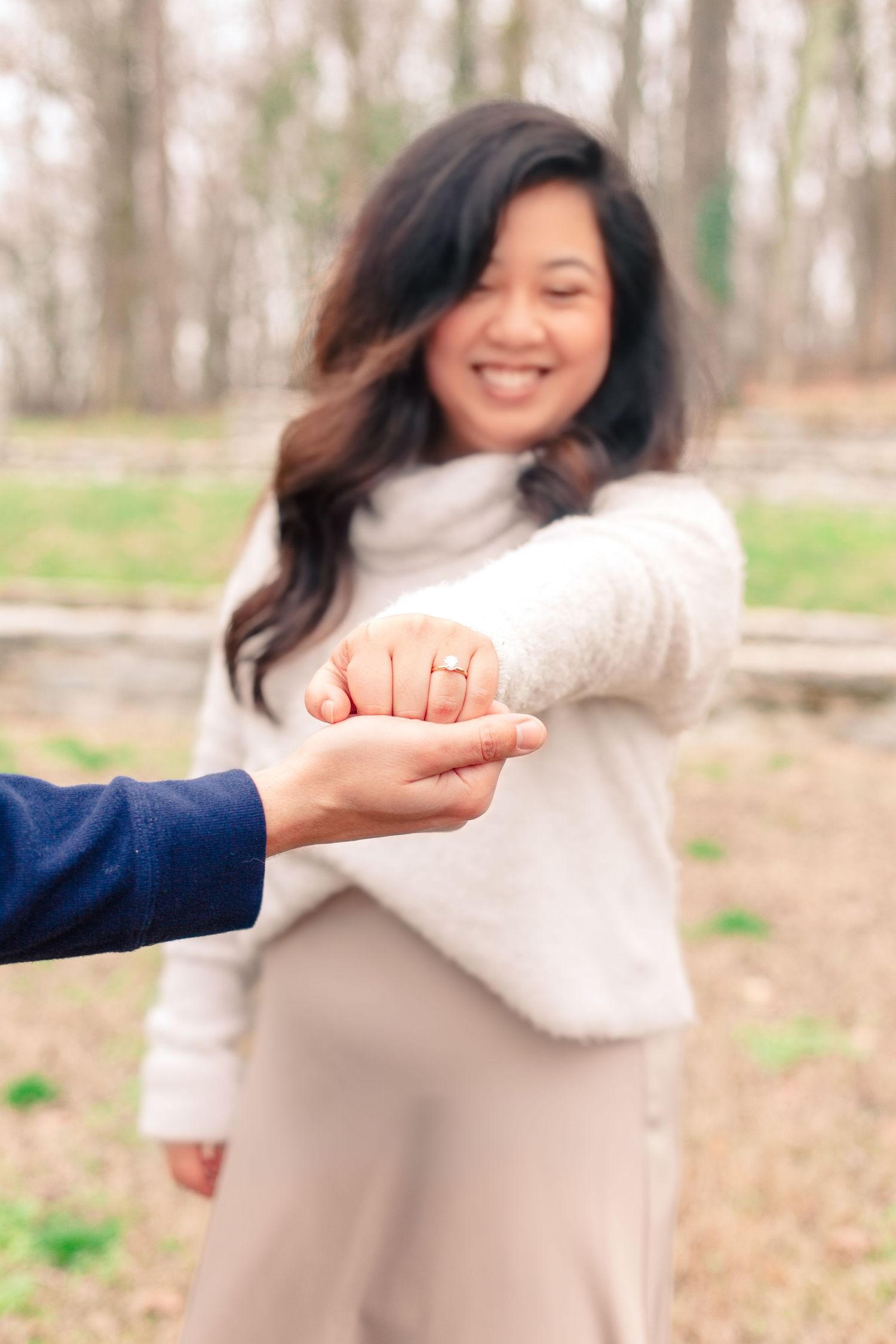 A person in a cream sweater playfully poses in a series of connected photos taken outdoors in a wooded area.
