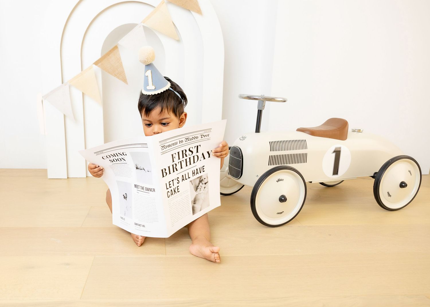White vintage-style toy car against a neutral background creates a charming prop setting.