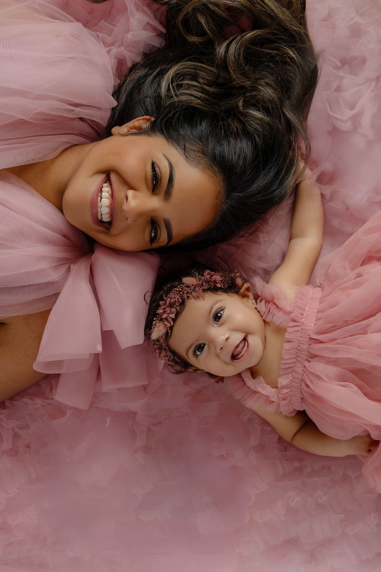 A series of glamour shots with a person lying on pink tulle fabric in elegant poses.