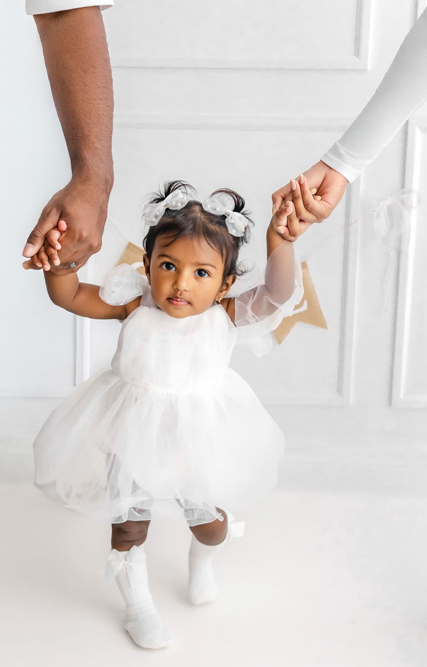 A series of walking shots in an all-white outfit against a minimalist white backdrop.