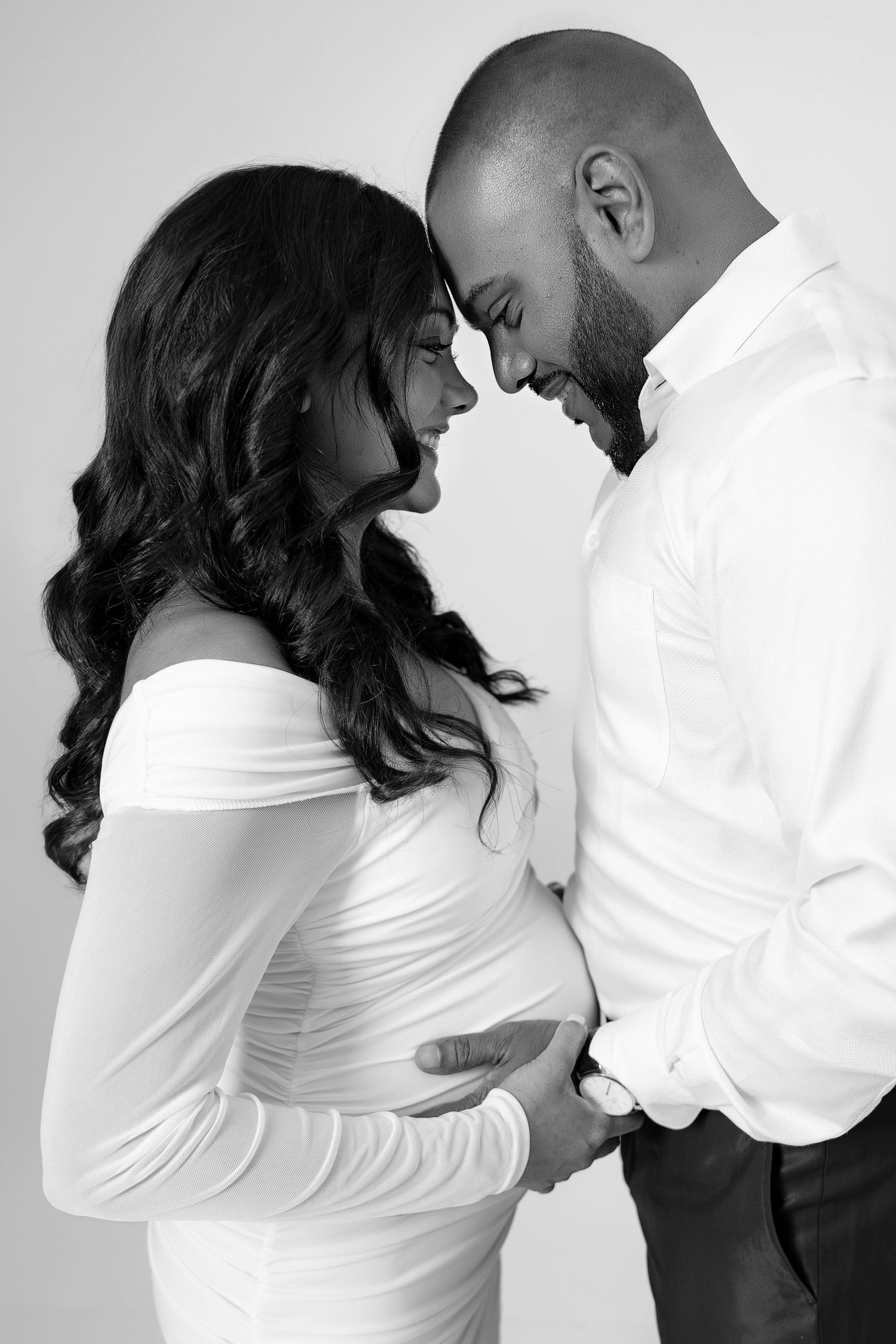 Black and white maternity photoshoot showing couple in intimate poses.