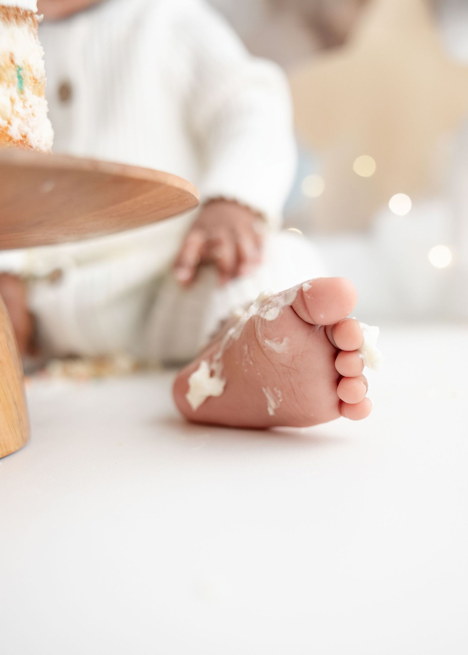 Close-up of baby feet during a cake smash photoshoot with frosting.