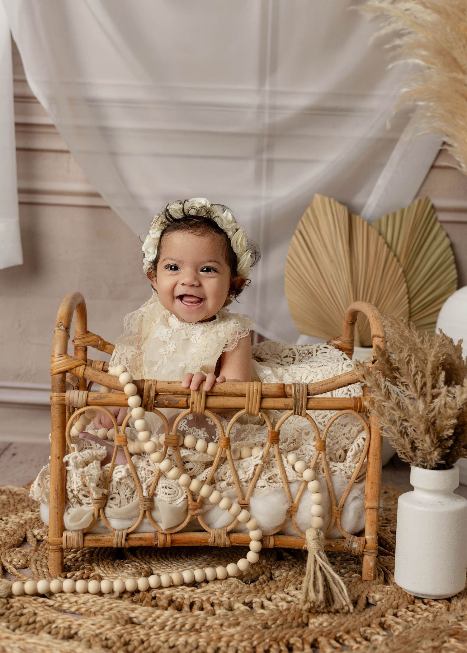 Baby photoshoot with rustic wooden decor and dried floral arrangements in neutral tones.