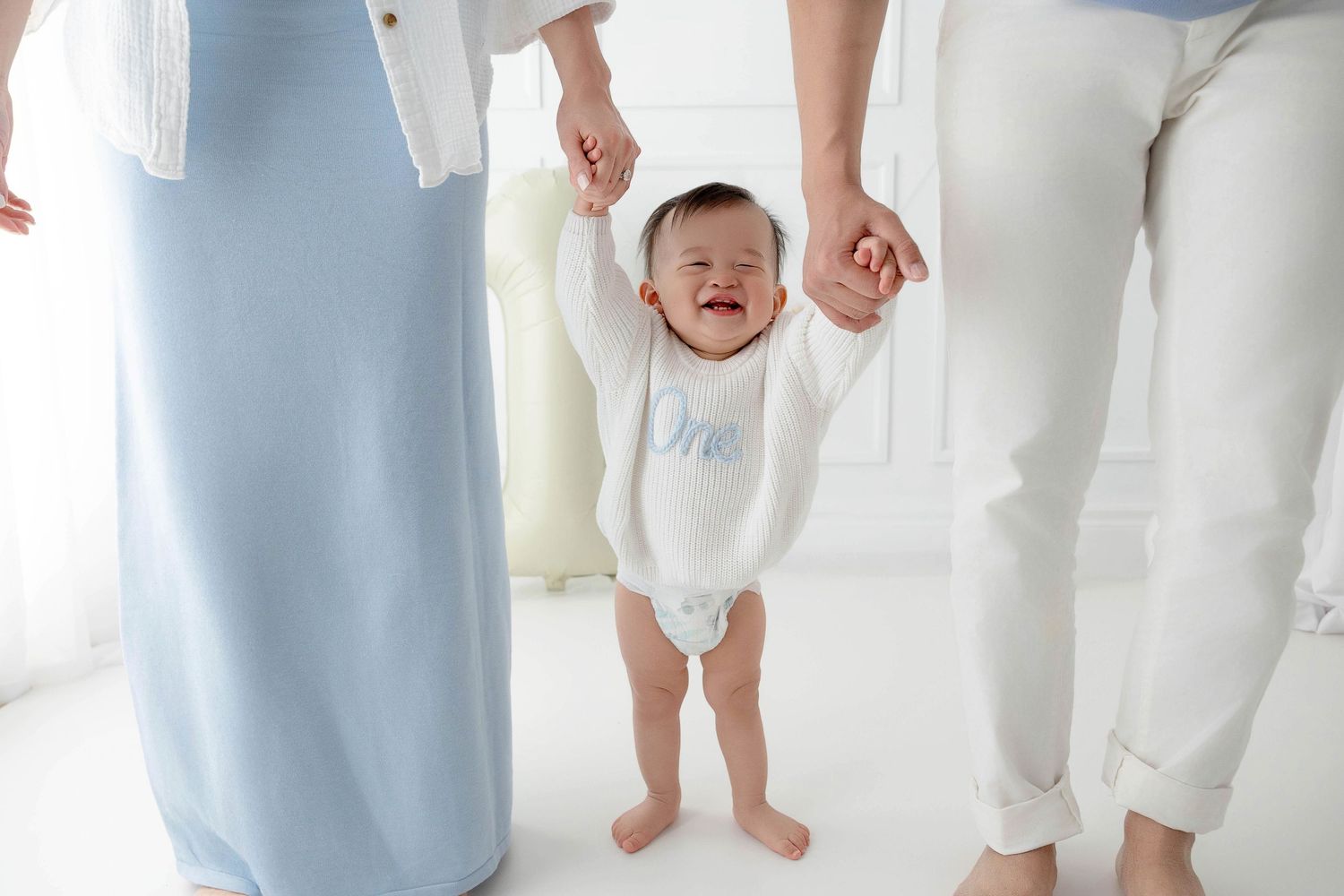 A collection of minimalist family portraits showing legs and feet in white and beige tones against a light background.