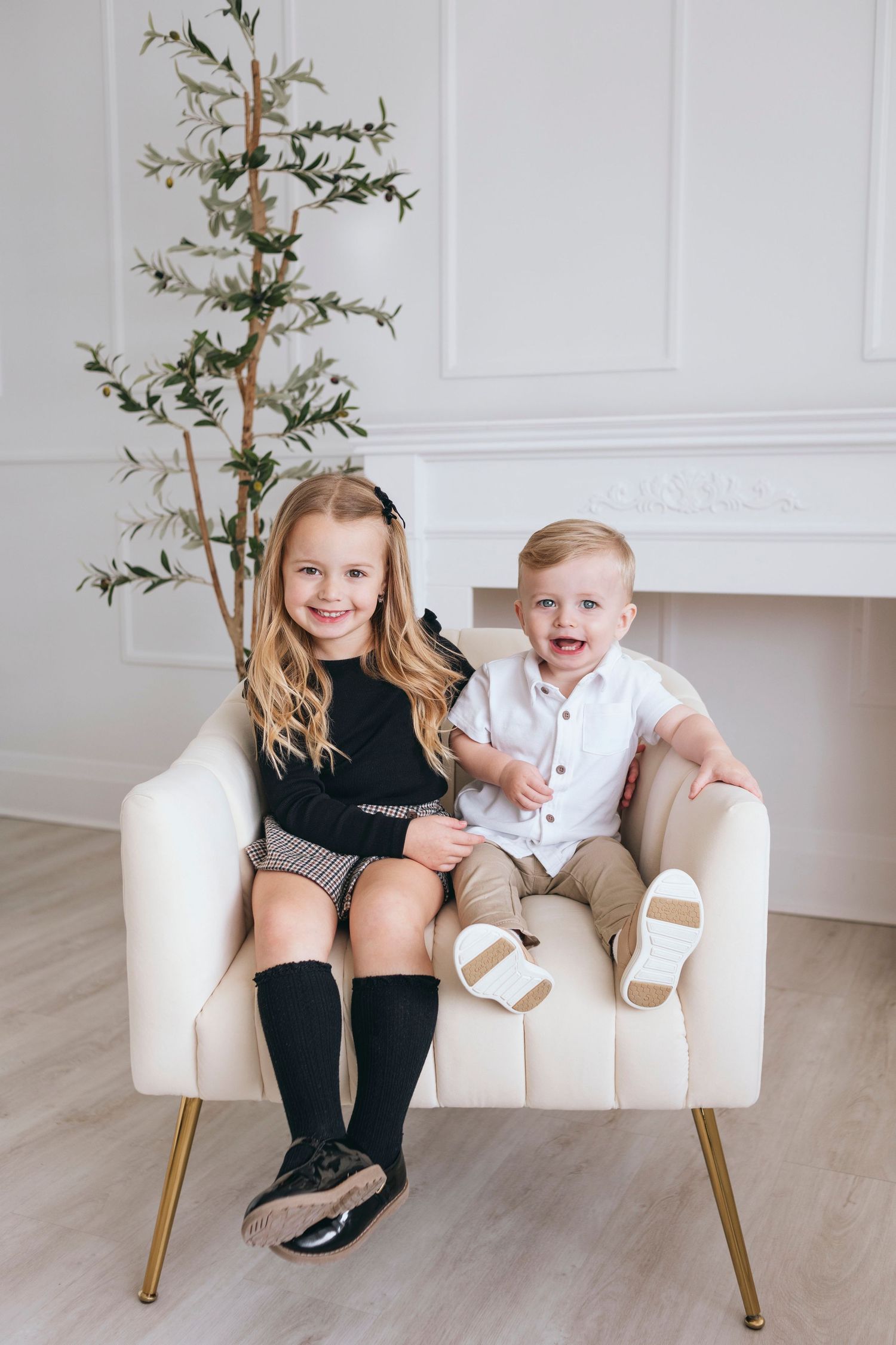 Modern studio photography with white walls, gold accent furniture and minimalist decor.