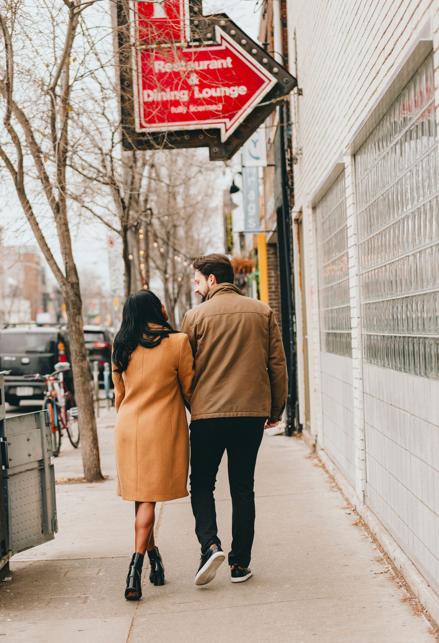 Couple walking together on a city sidewalk on an autumn day.