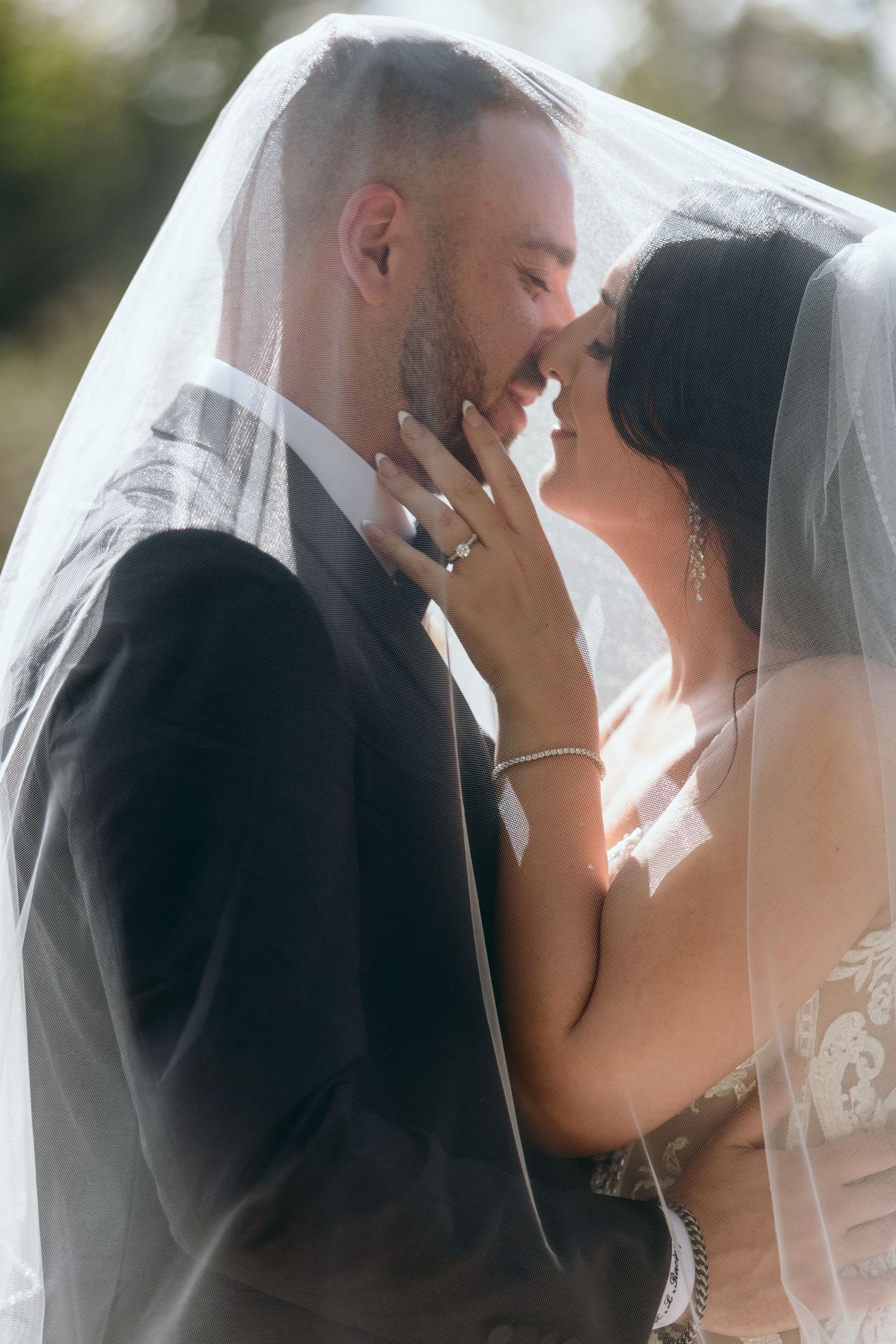 Intimate wedding portraits captured with soft lighting and flowing veil.