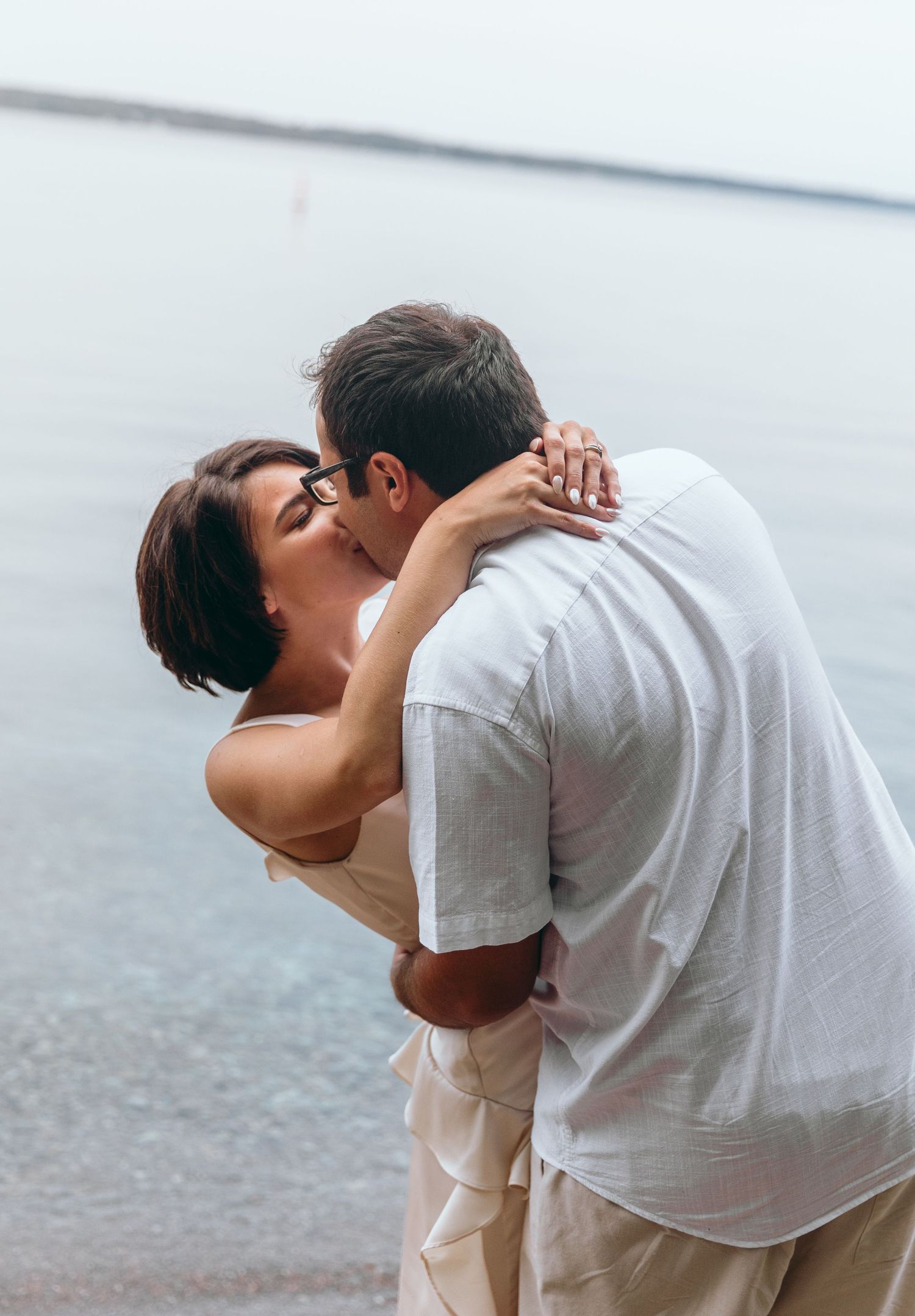 Intimate moment shared between couple by the water.