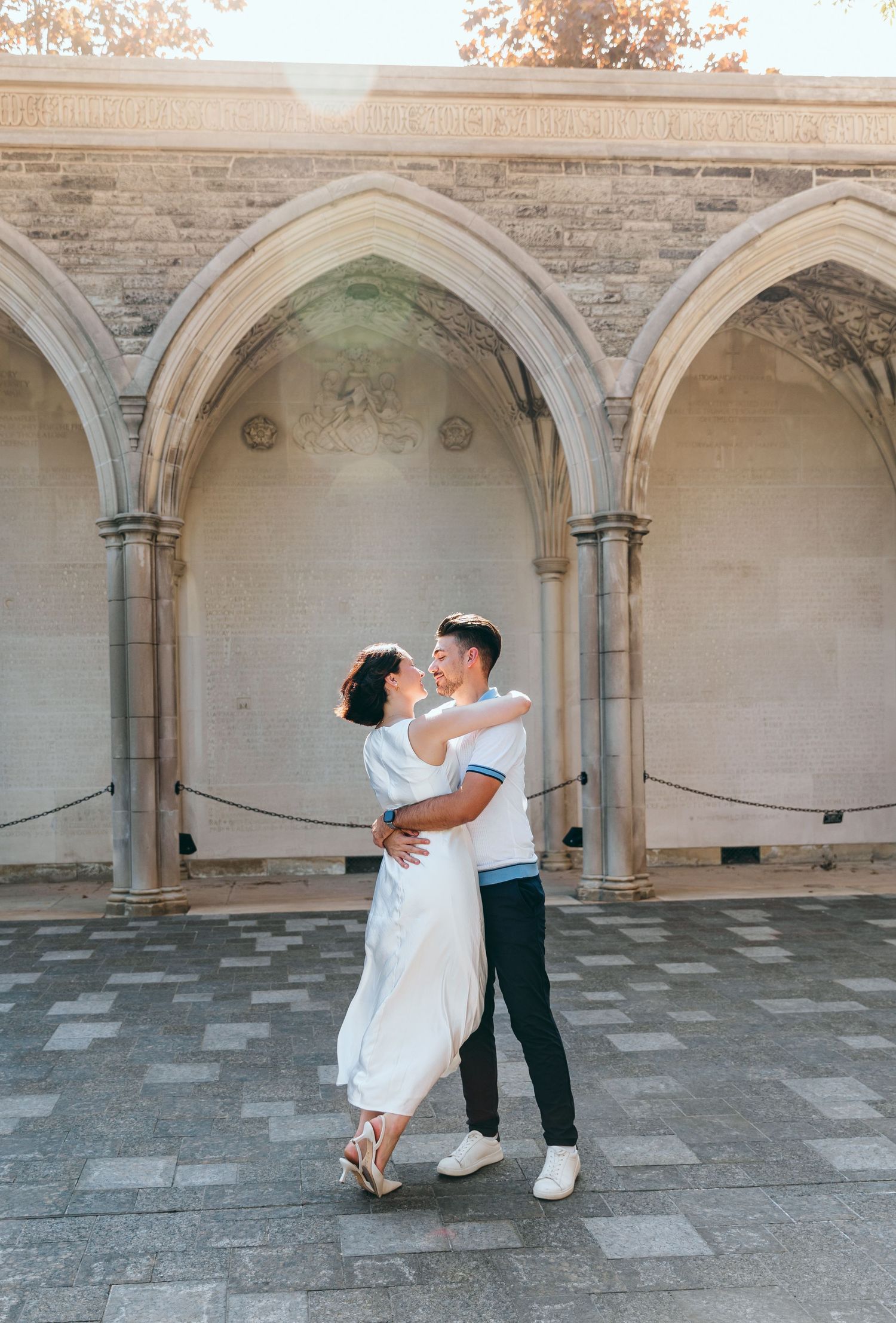 A couple dances together under ornate stone archways.