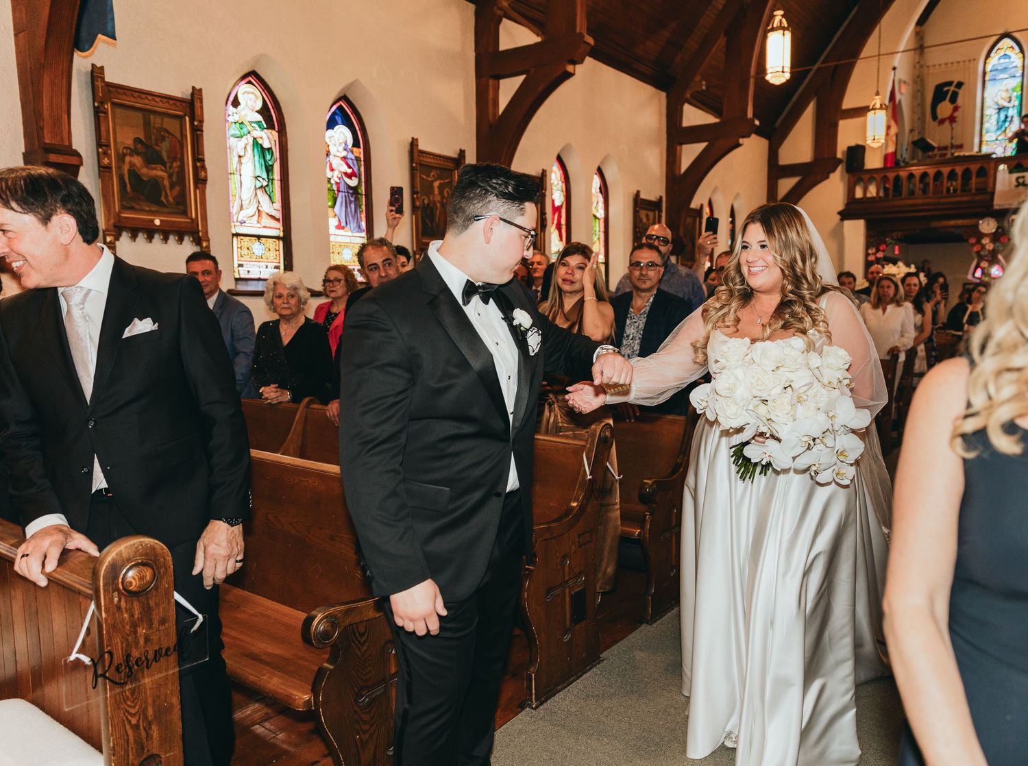 Wedding guests dancing and celebrating in a traditional church setting.