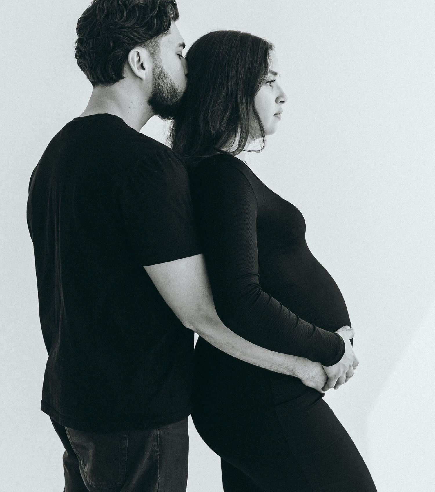 A minimalist black and white portrait of an embracing couple.