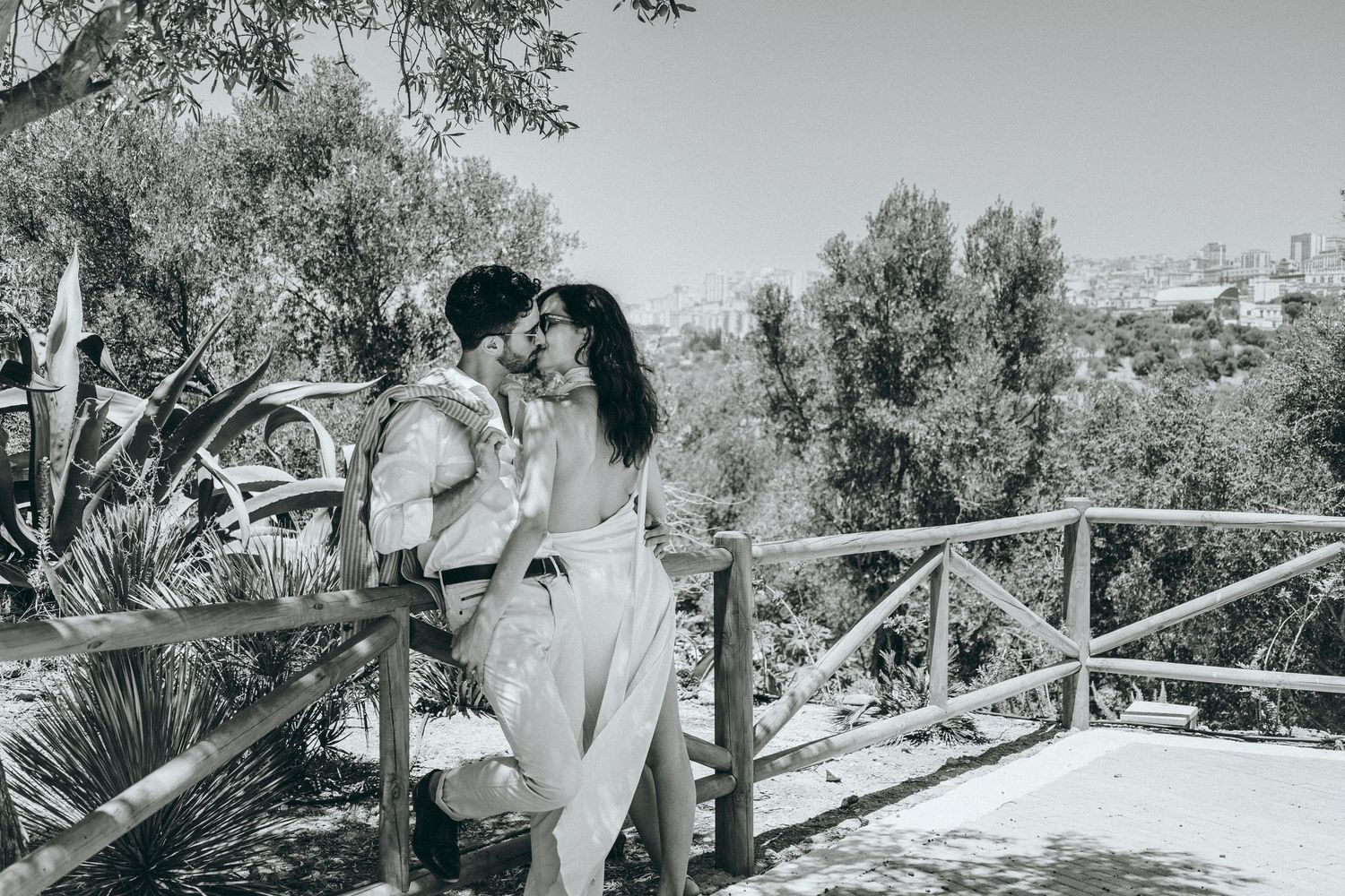A romantic scene unfolds against a scenic backdrop with stone architecture.