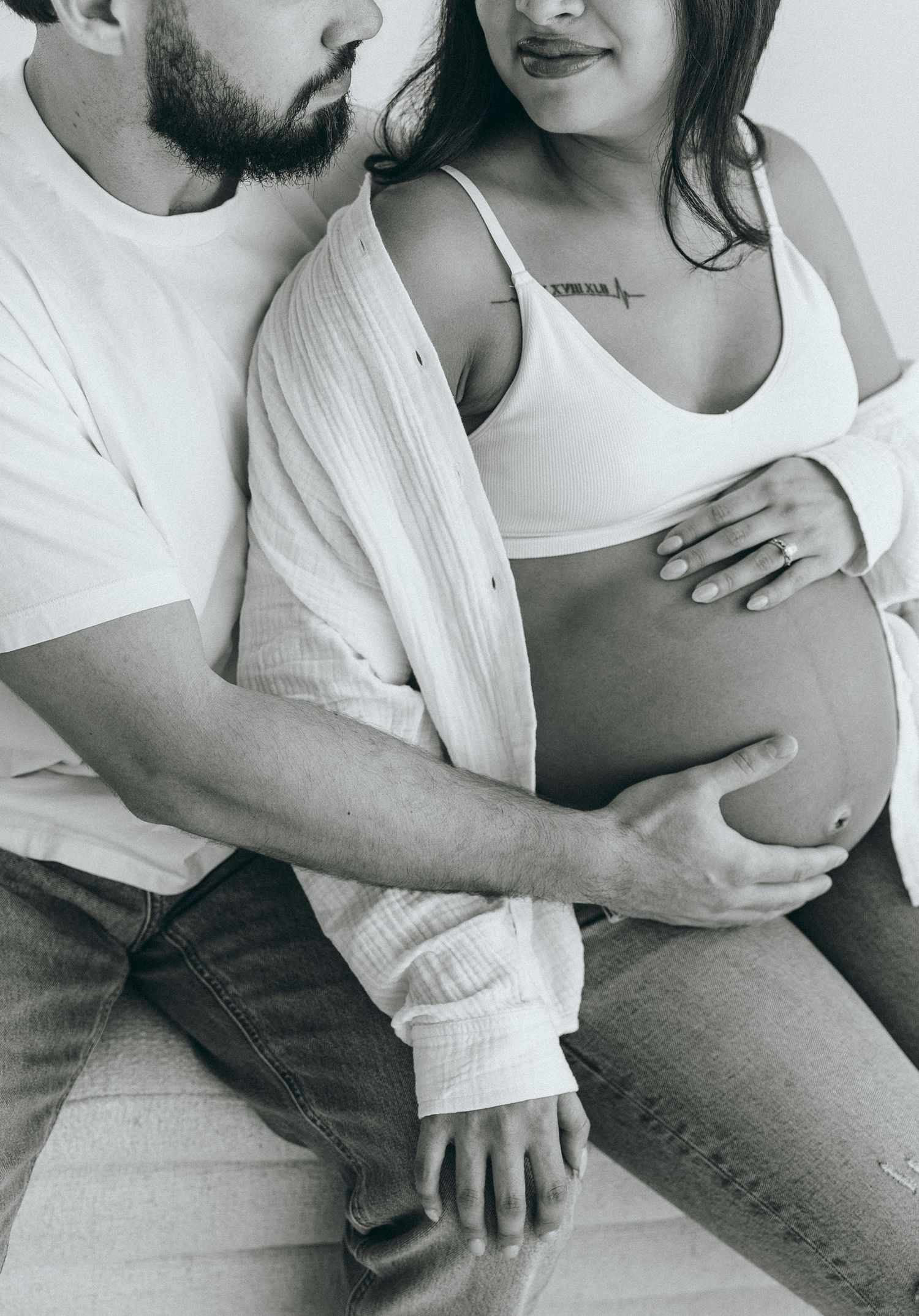 Intimate black and white maternity photos showing couple's tender moments.