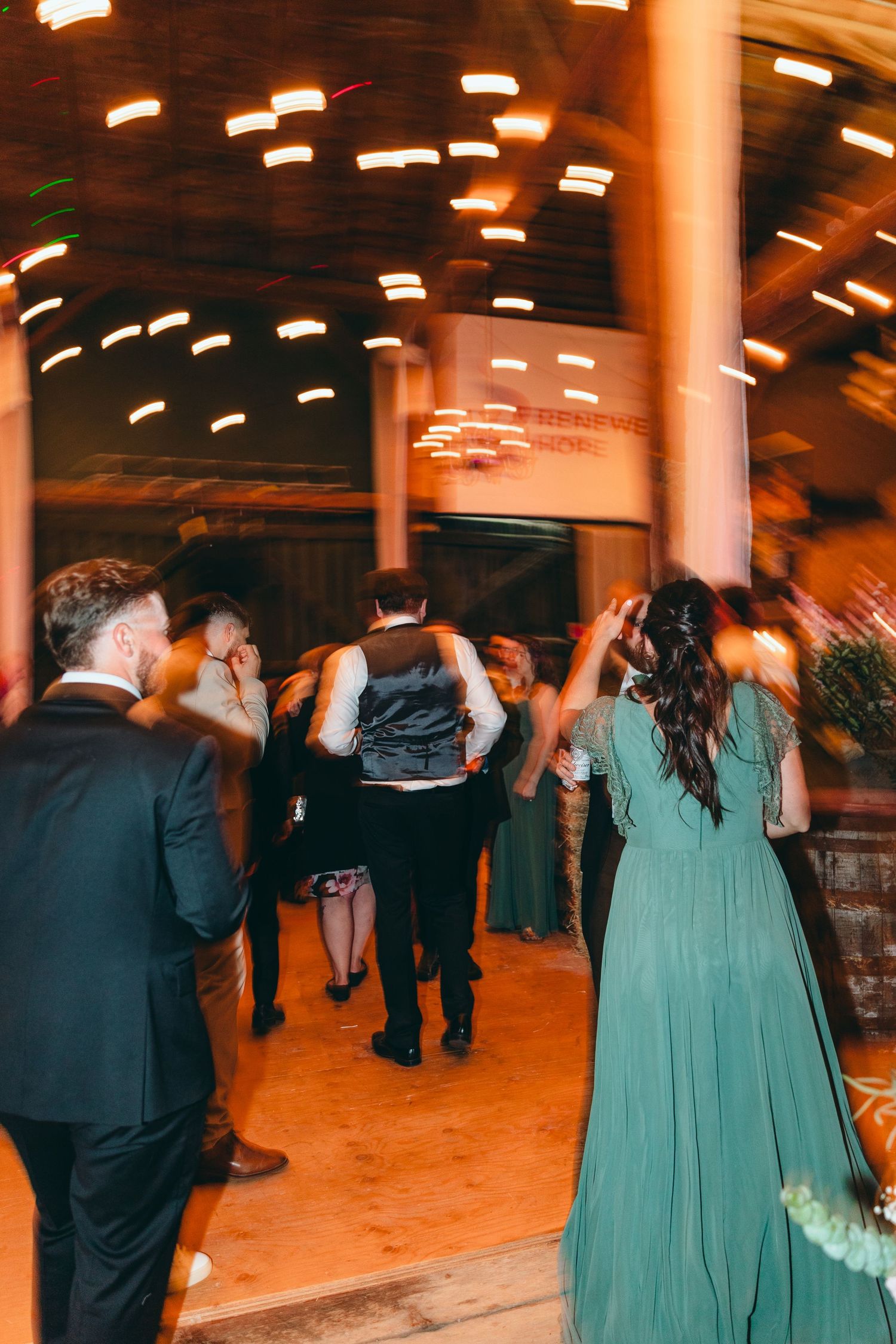 Blurred motion shots of wedding party dancing, with bridesmaids in teal dresses visible.