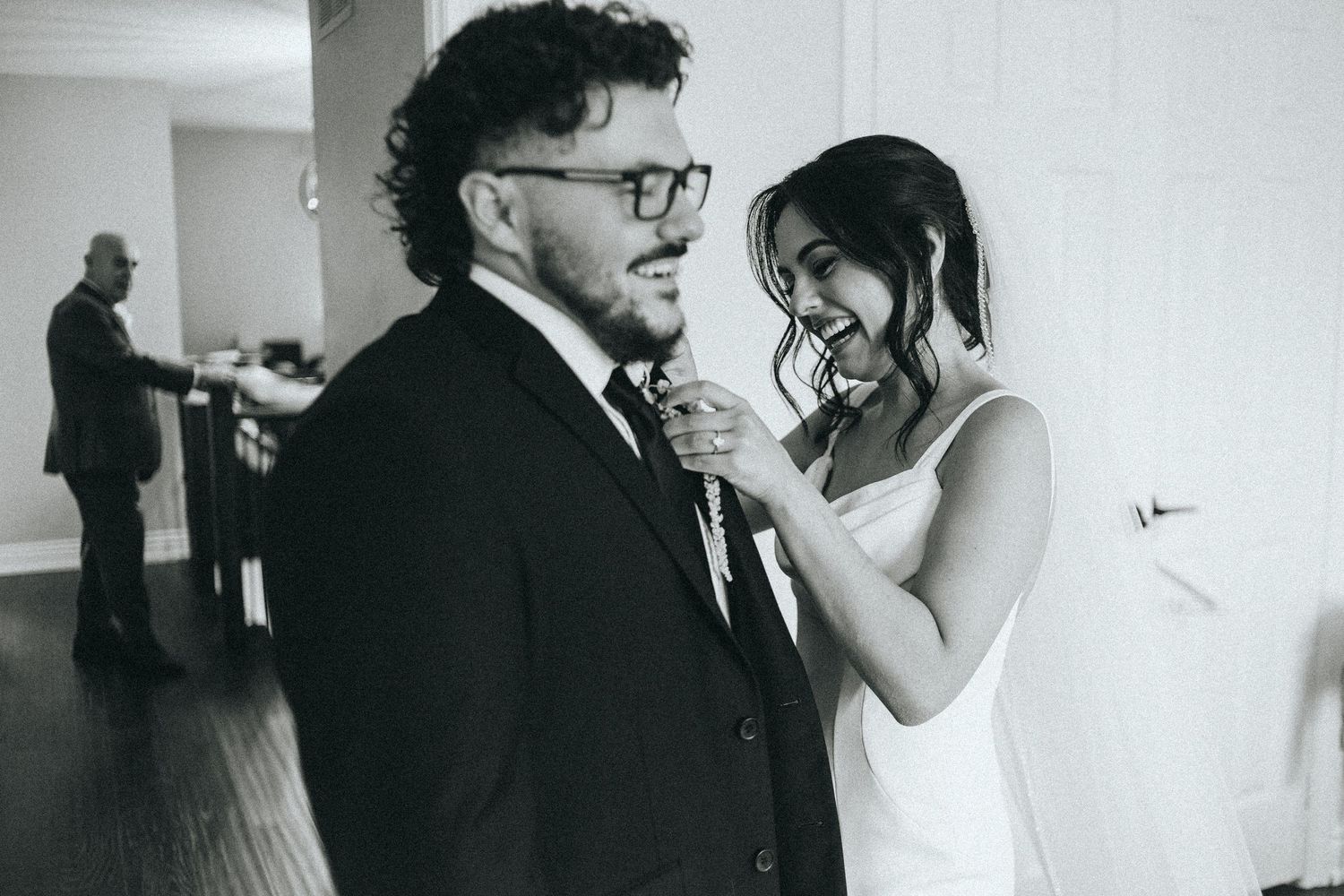 Black and white photo of couple sharing an emotional moment during wedding preparations.