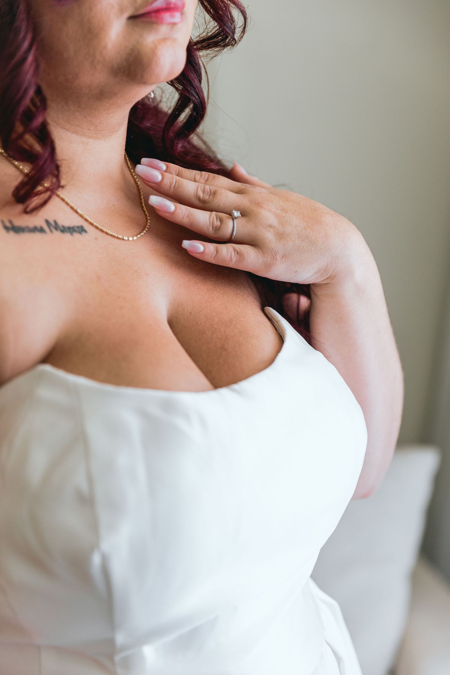 Detail shots of white wedding dress neckline with delicate jewelry accents.