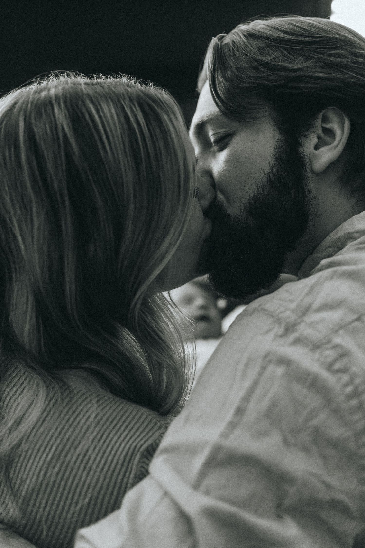 Black and white intimate portrait of two people in a tender moment.