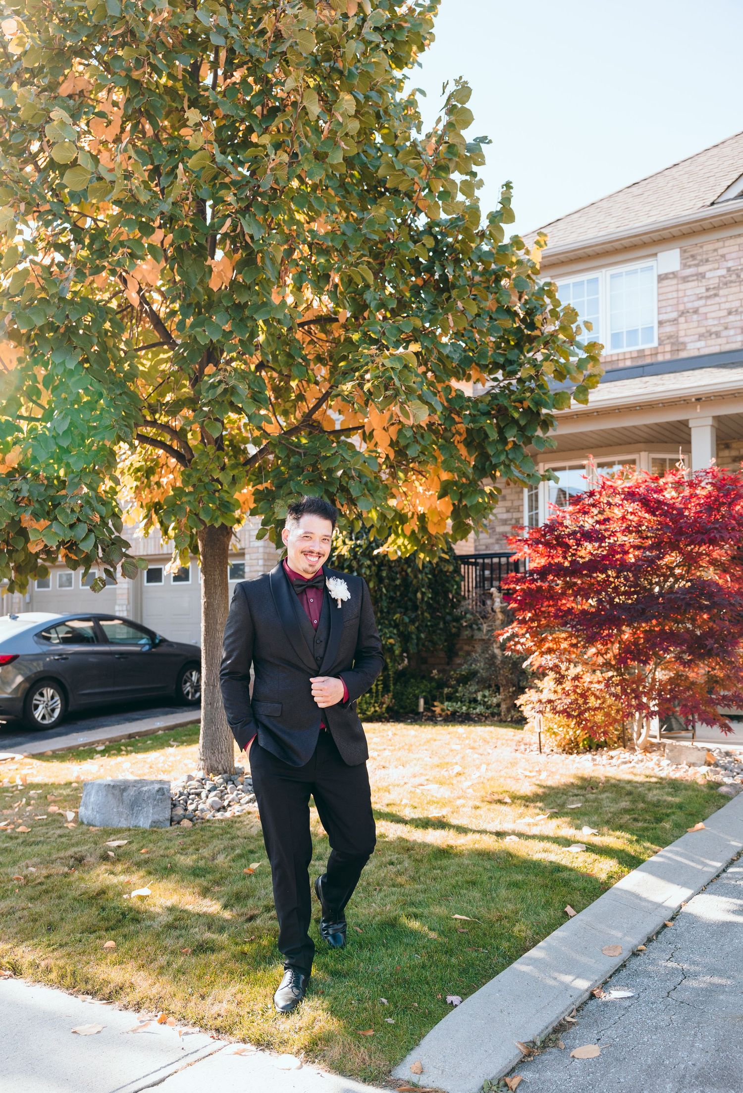 Autumn outdoor wedding photos with trees showing golden foliage in residential setting.