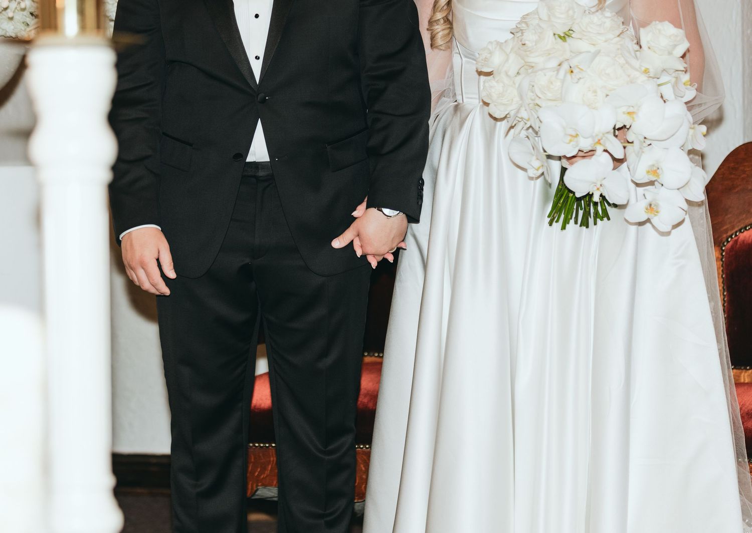 Wedding party members in formal attire stand together at venue entrance.