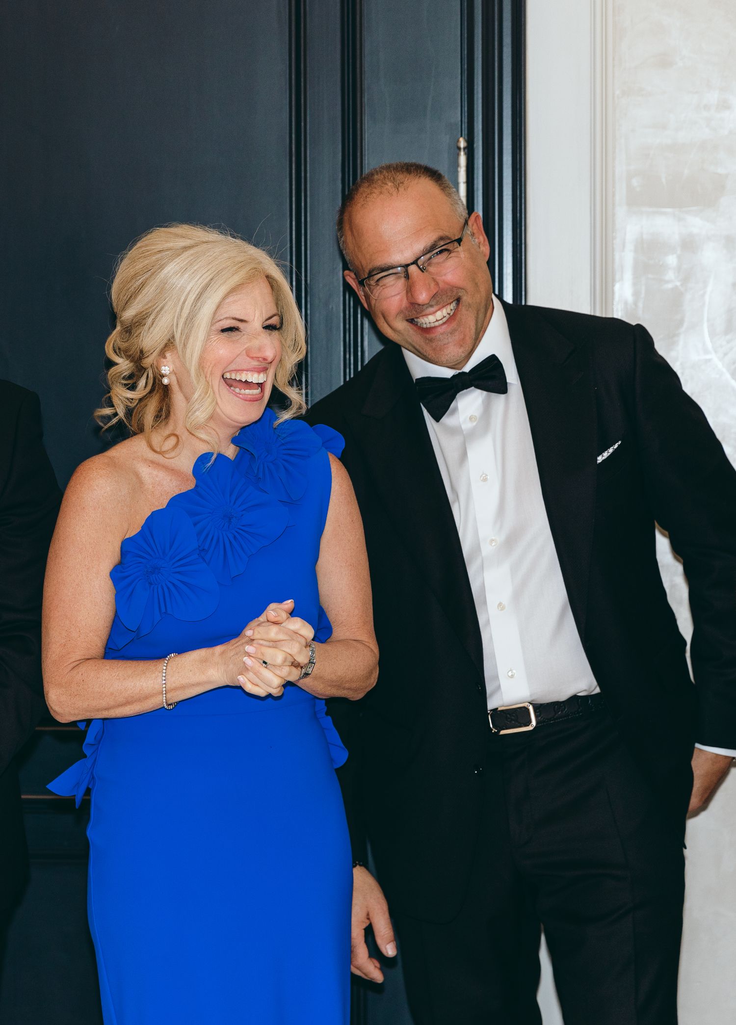 Joyful moment shared between guests in formal attire at elegant event.