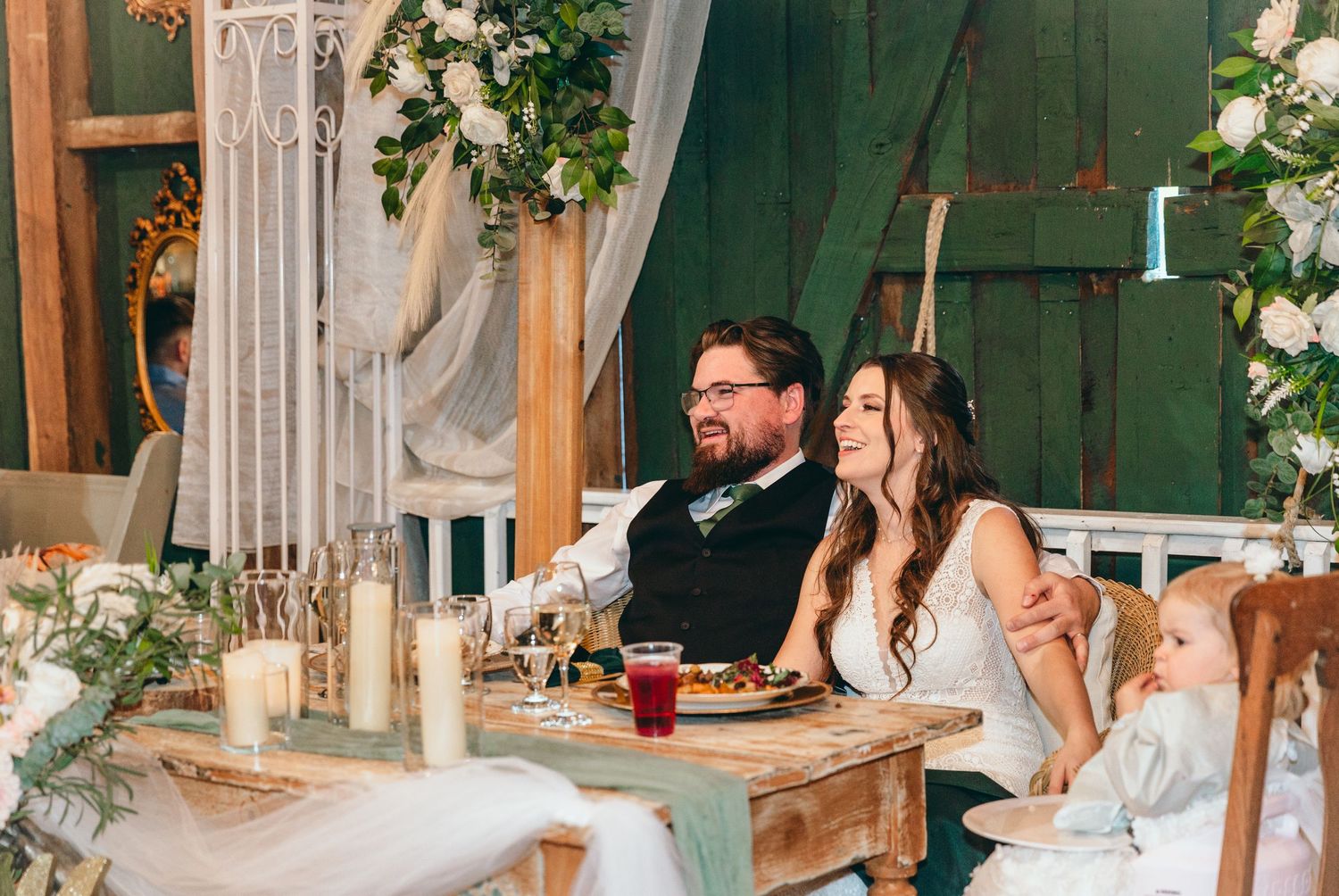 Guests enjoying drinks and conversation at rustic barn wedding reception with wooden decor.