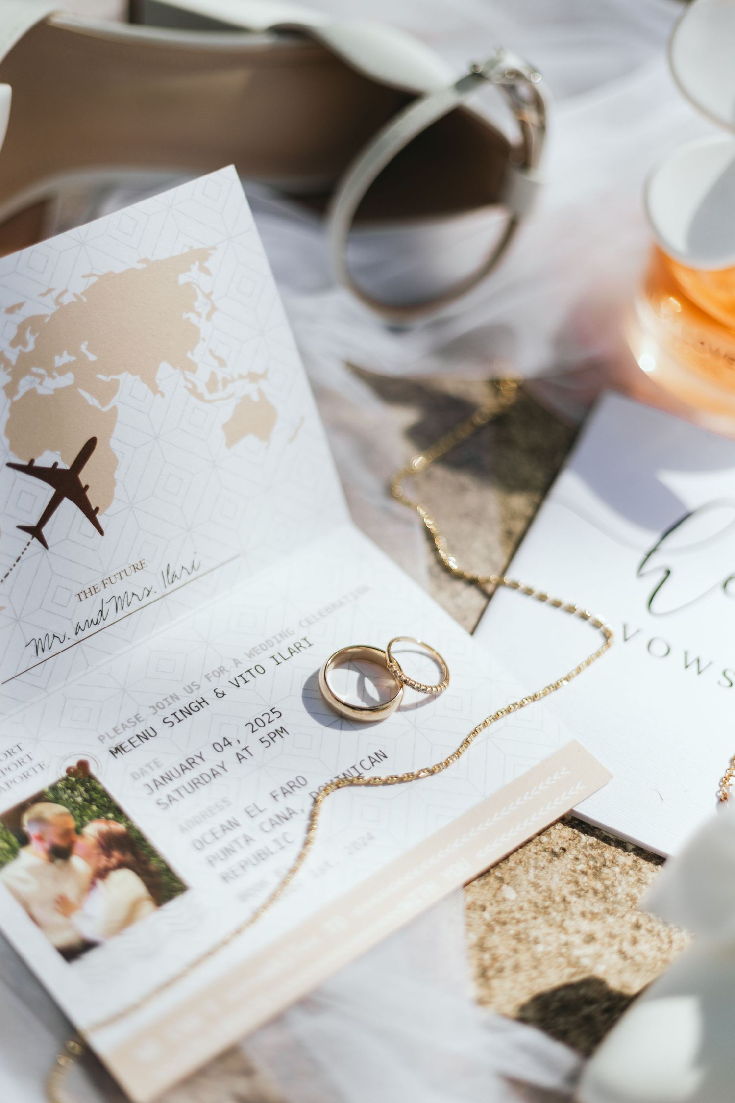 Wedding stationery and rings arranged artistically with travel-themed details.