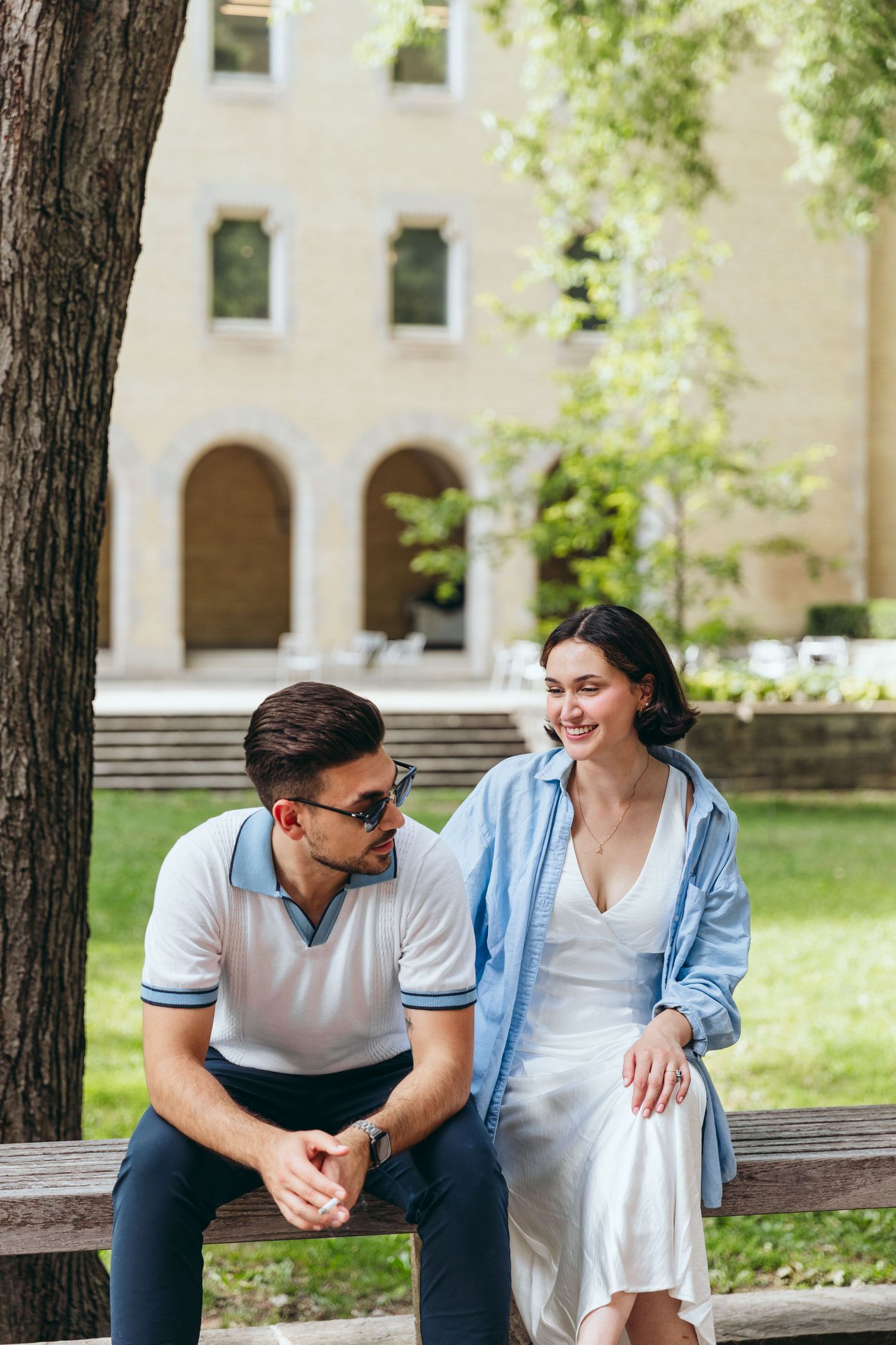 Casual outdoor photoshoot showing candid moments between a couple on a bench.