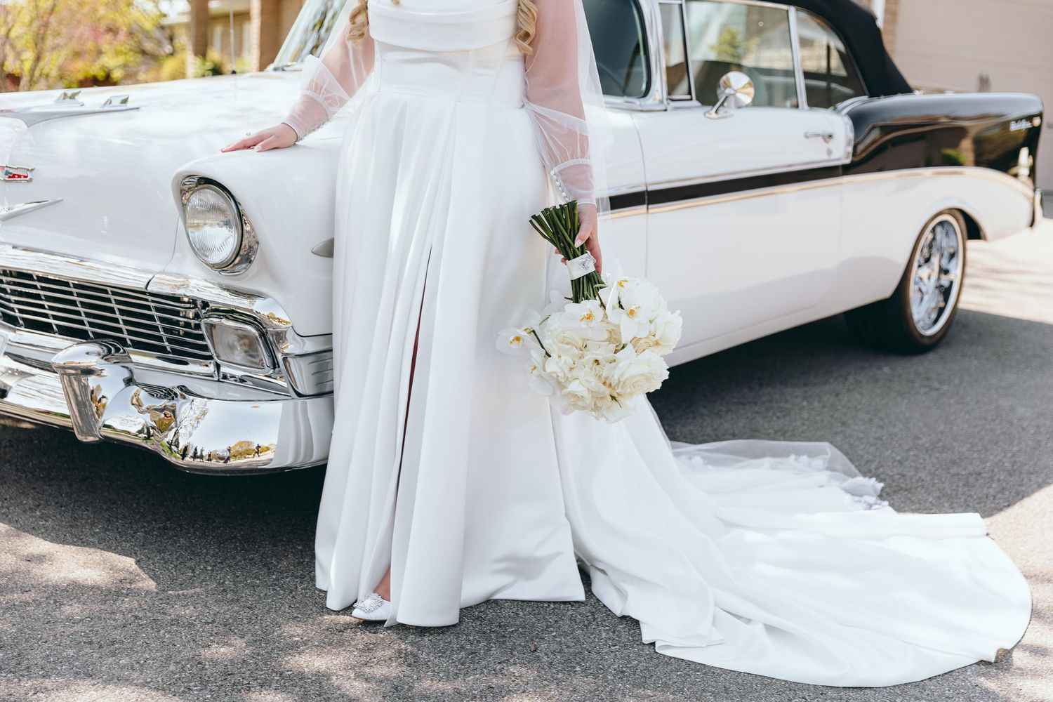 Classic white vintage car featured in elegant wedding photos.