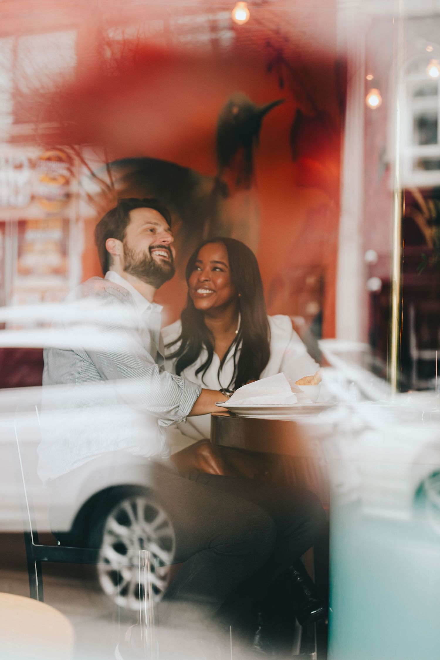 Candid moment captured through window reflection at a restaurant.