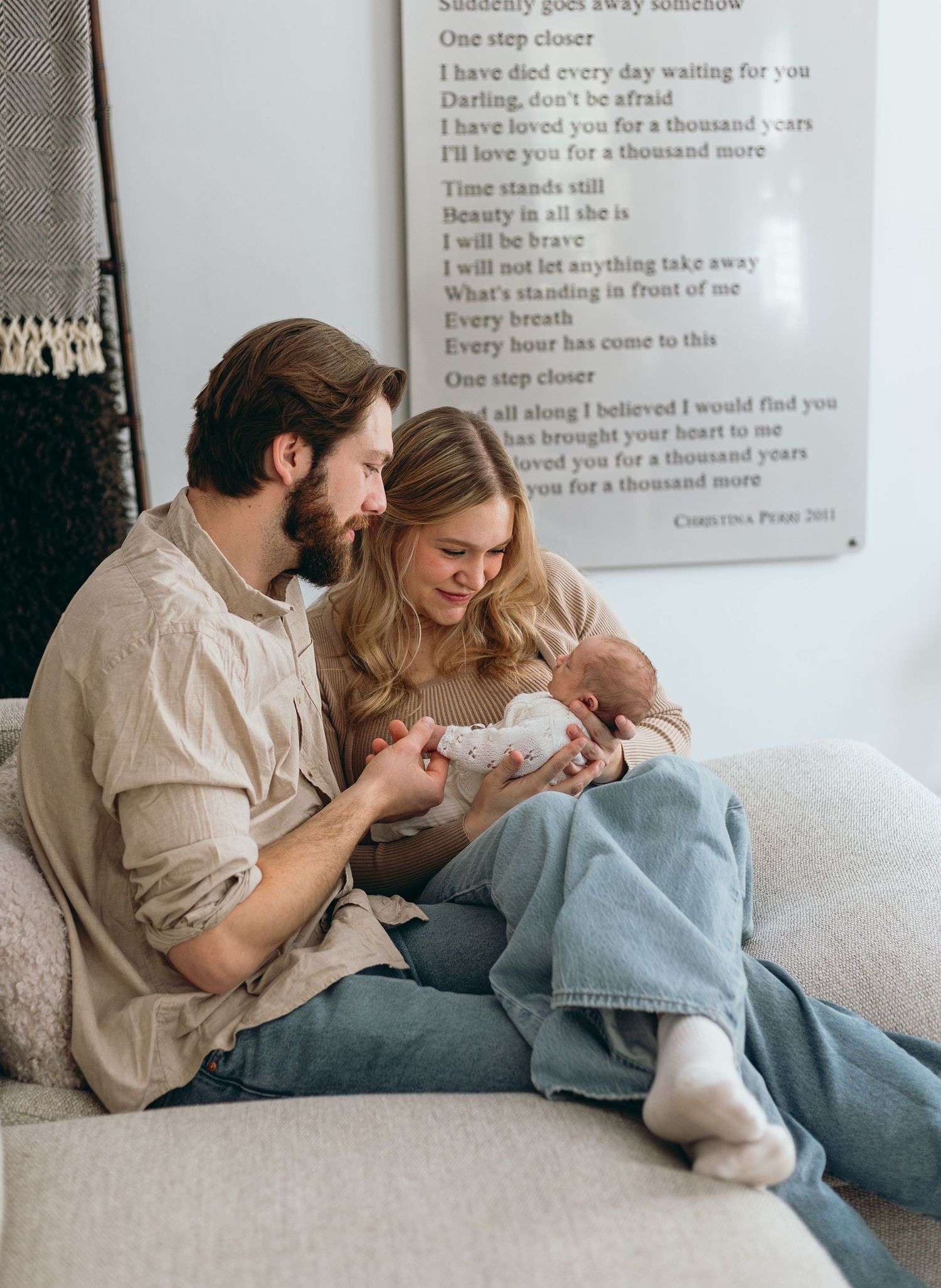 Candid family moment photographed against white wall with text art in the background.