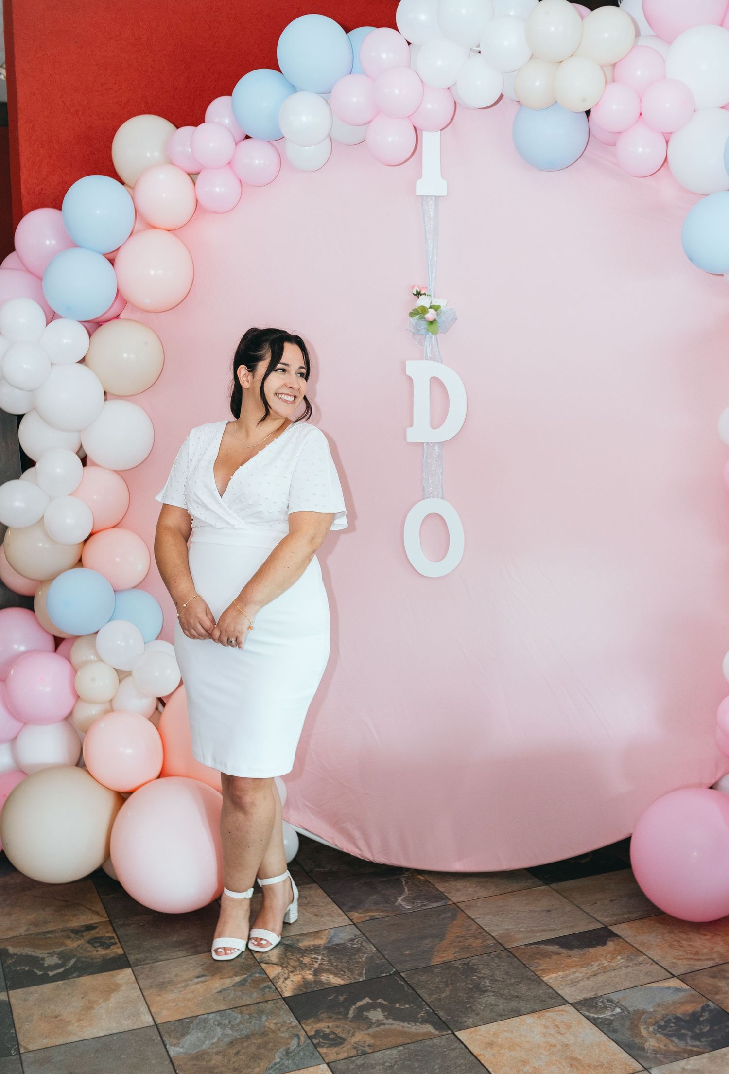 Pink and white balloon arch installation creates dreamy backdrop for celebration.