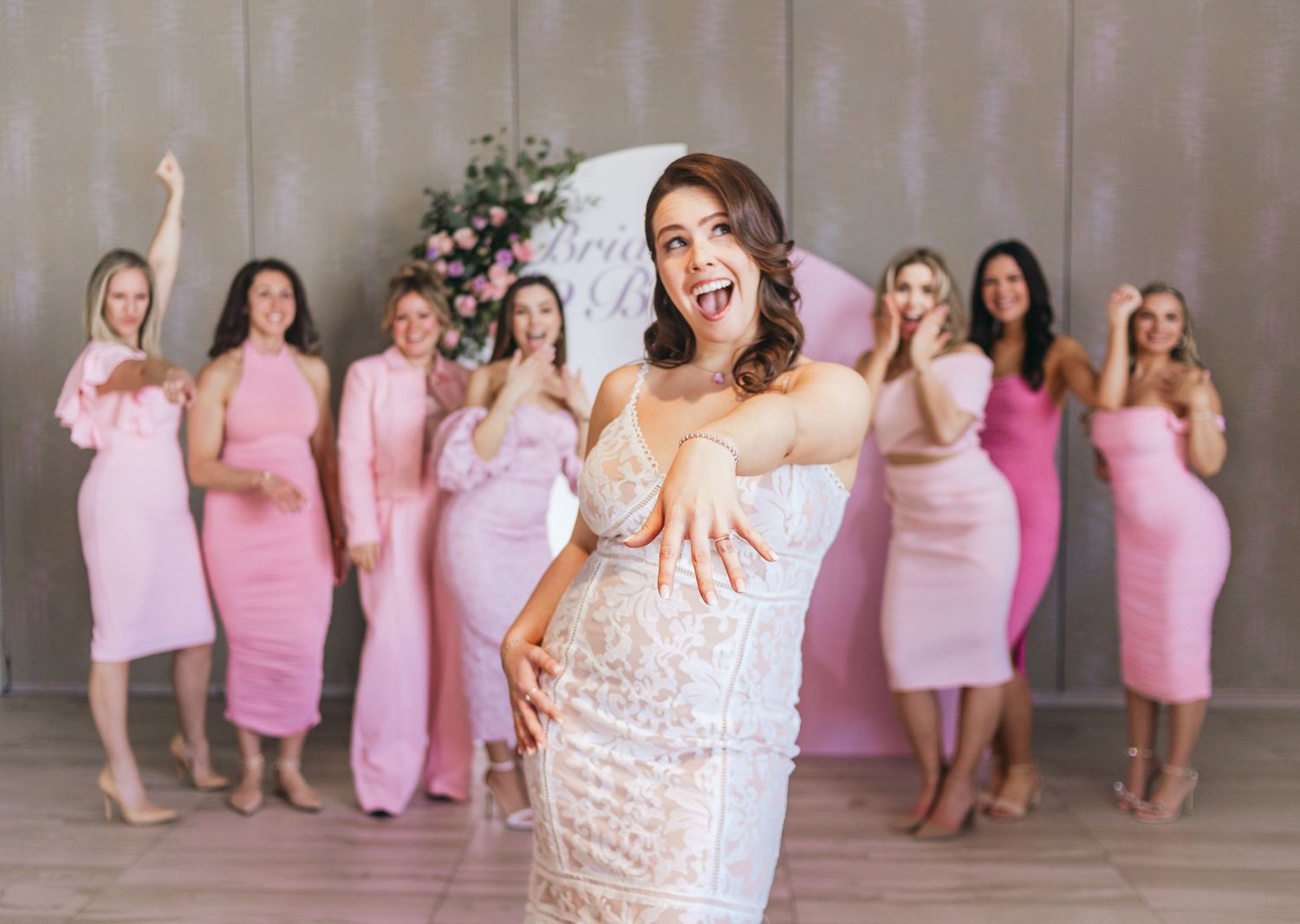 Bridal shower celebration with attendees wearing matching pink dresses.