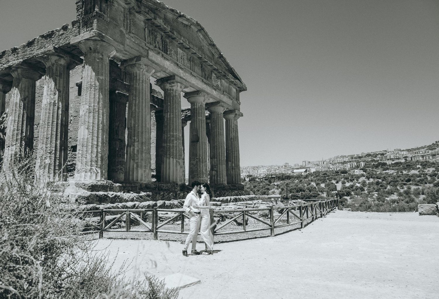 Ancient Greek temple ruins with Doric columns photographed in panoramic black and white view.
