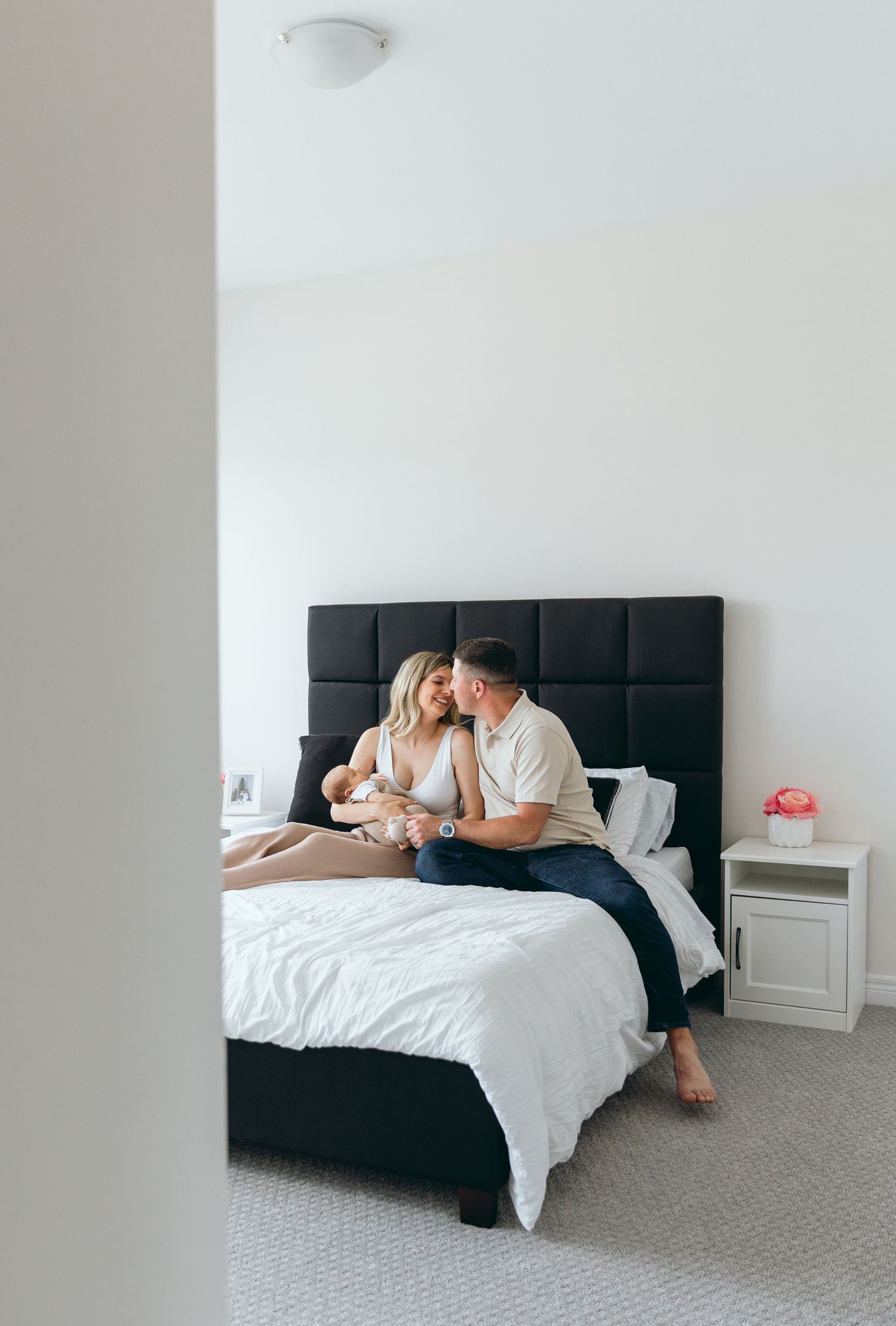 Intimate moments captured of a couple relaxing together on a bed with white linens.