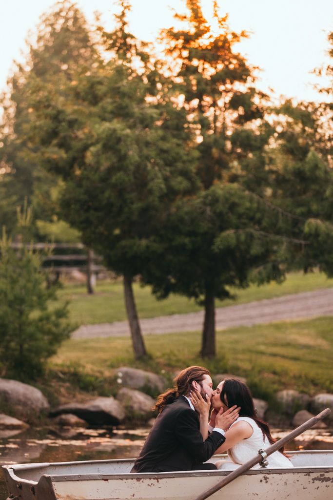 Sunset wedding photo of a couple sharing an intimate moment by a lake.