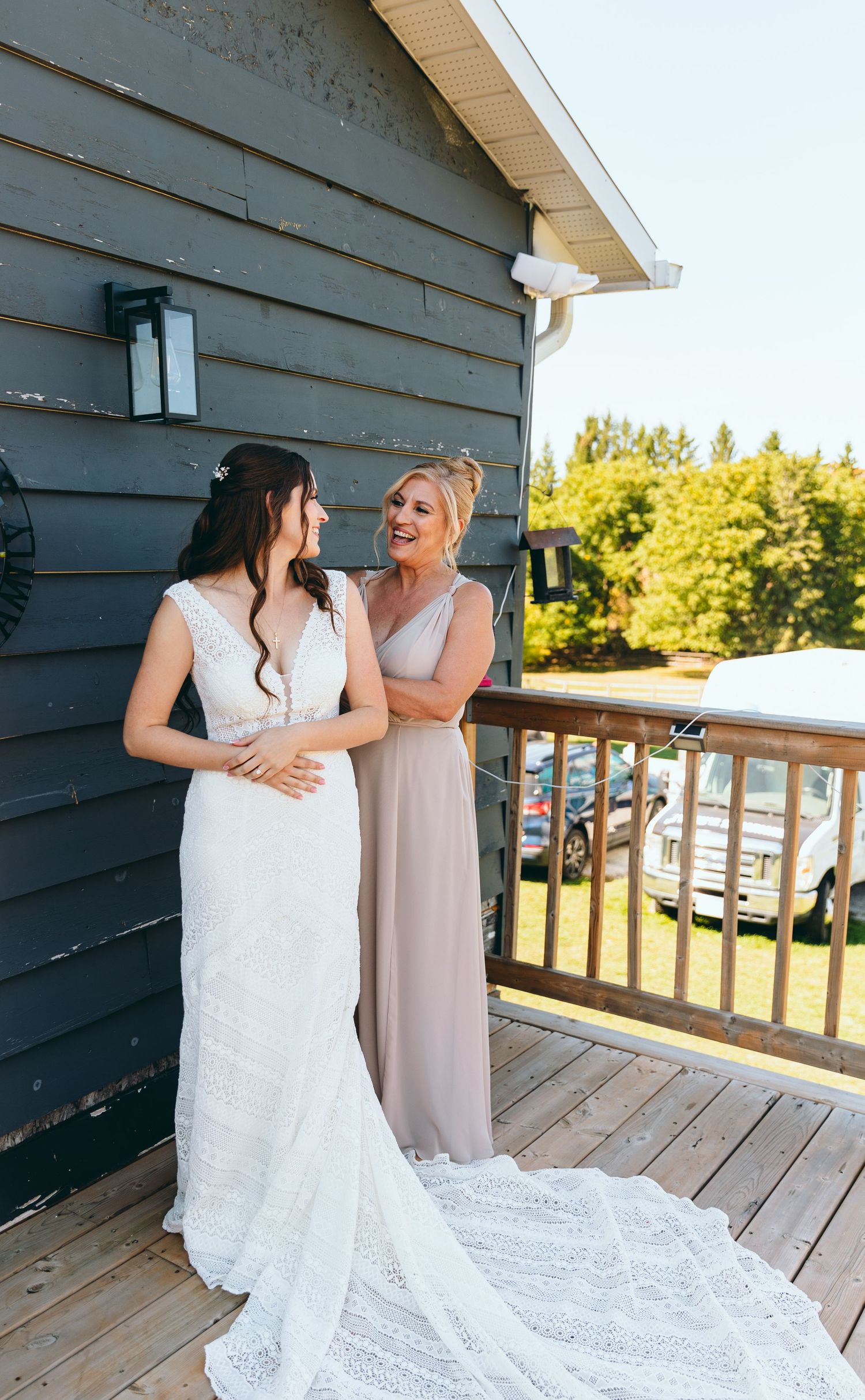 Two people sharing an emotional moment on a wooden deck during a wedding.