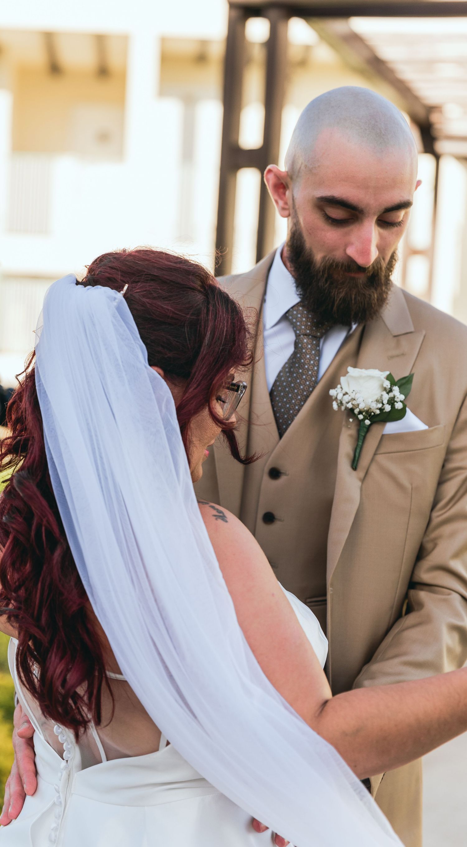 Intimate wedding moment shared between couple under covered walkway.