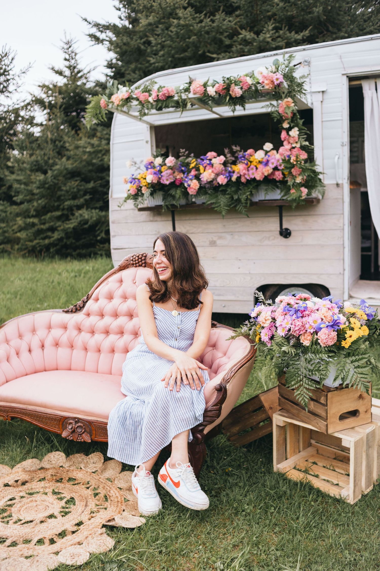 Pink vintage couch with floral decorations set up outdoors for event photography.