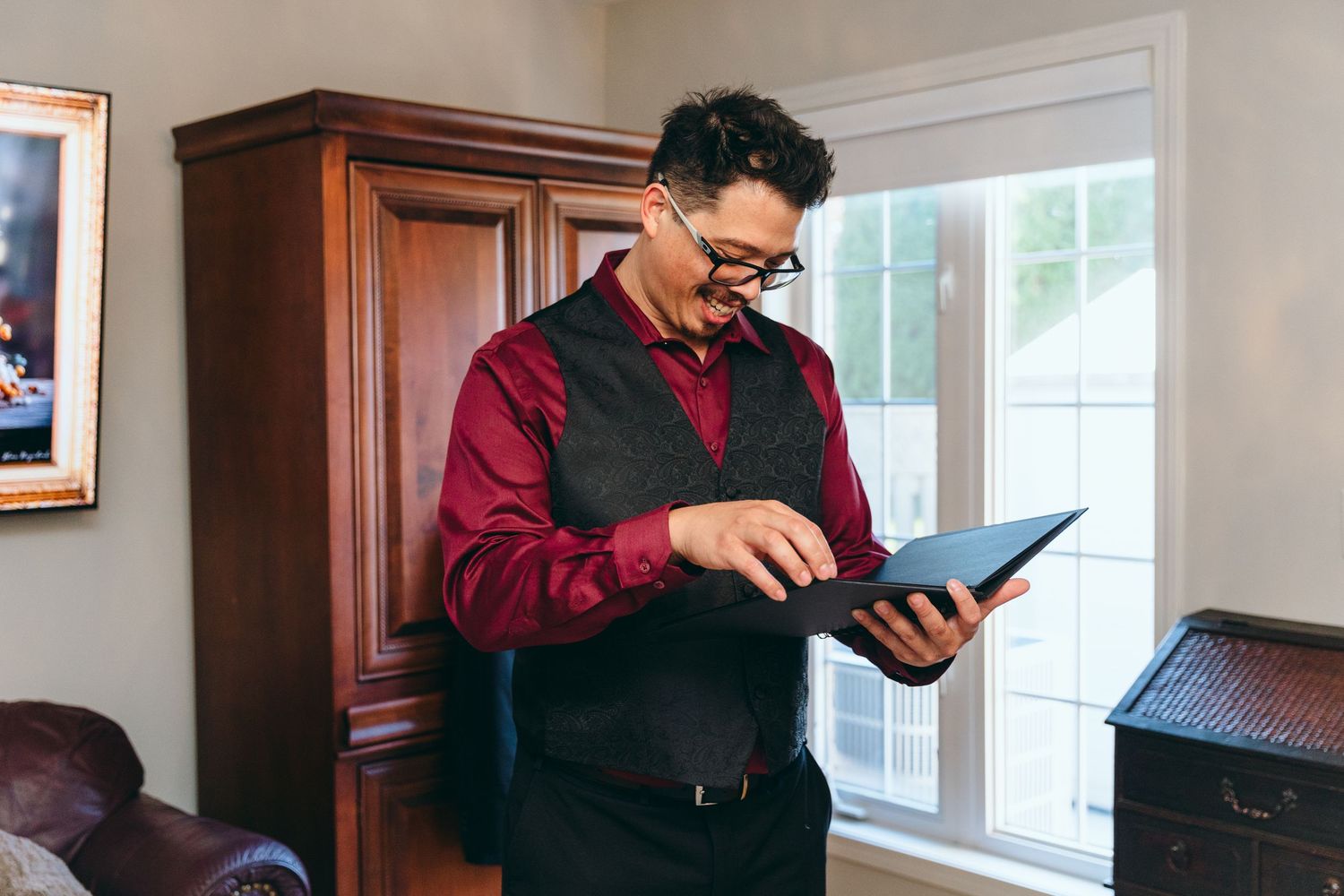 Person in burgundy attire reading from a tablet device in a bright room.