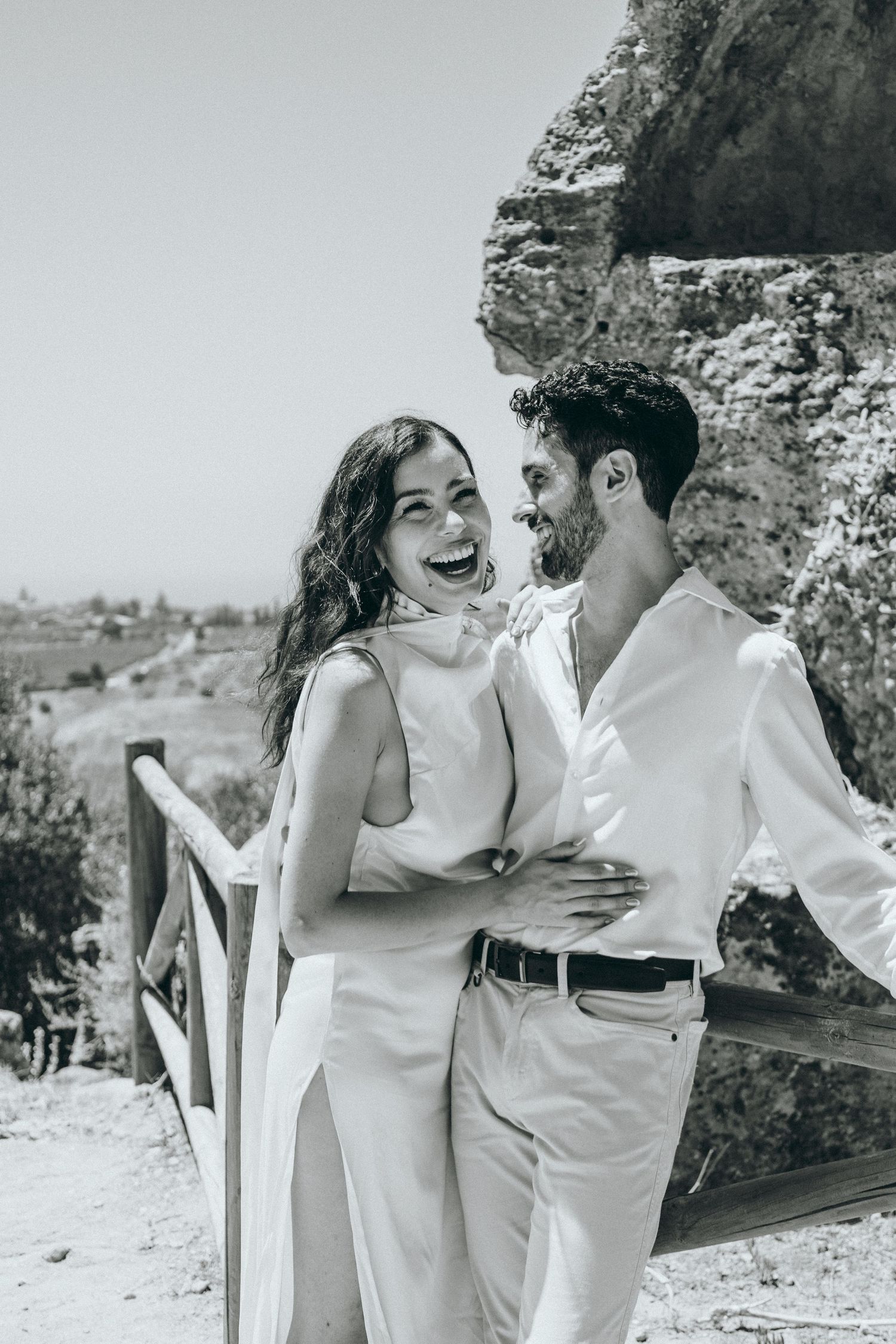 Candid black and white photos showing joyful laughter and embraces outdoors.