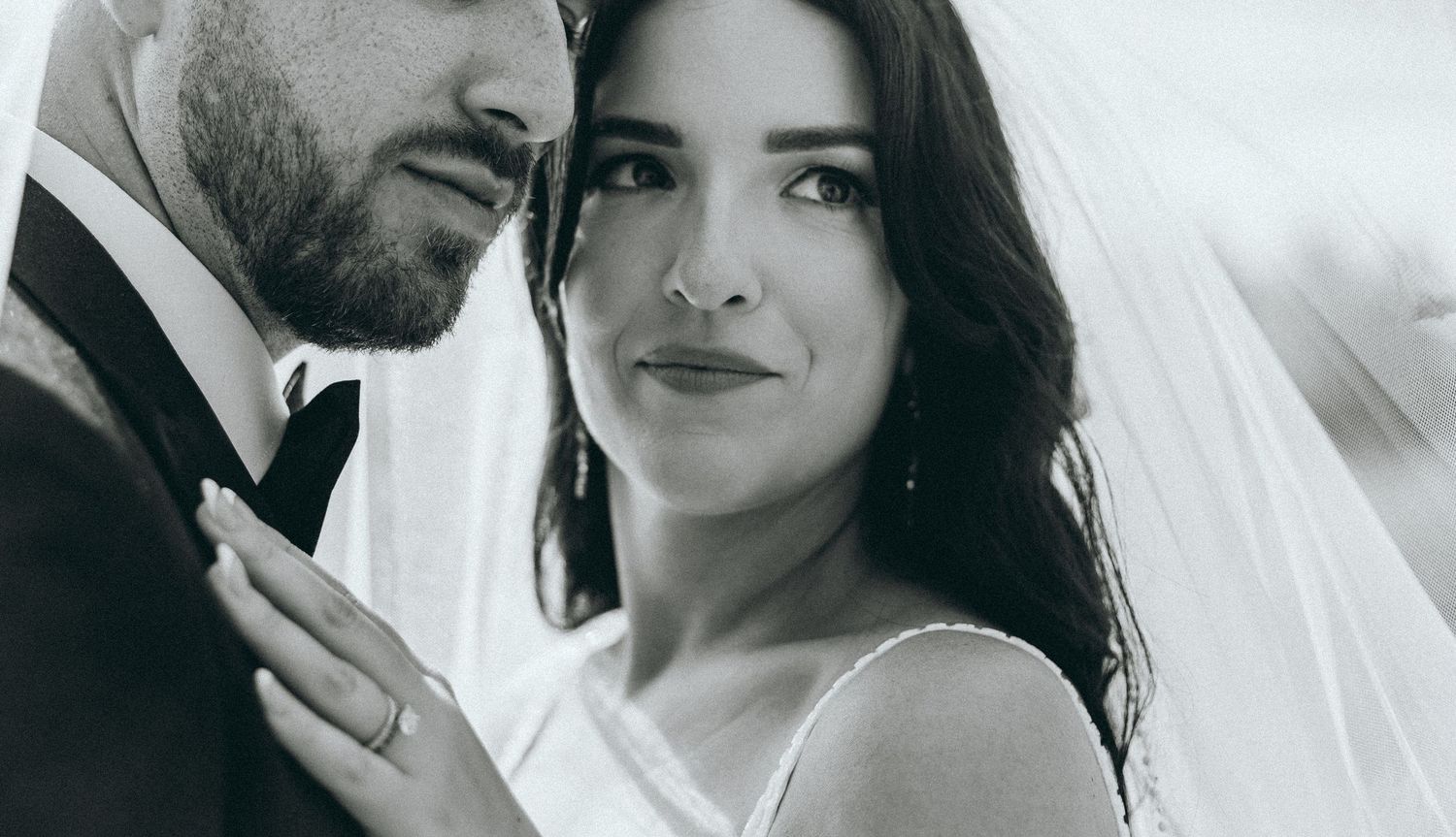 Black and white close-up portrait of newlyweds sharing an intimate moment.