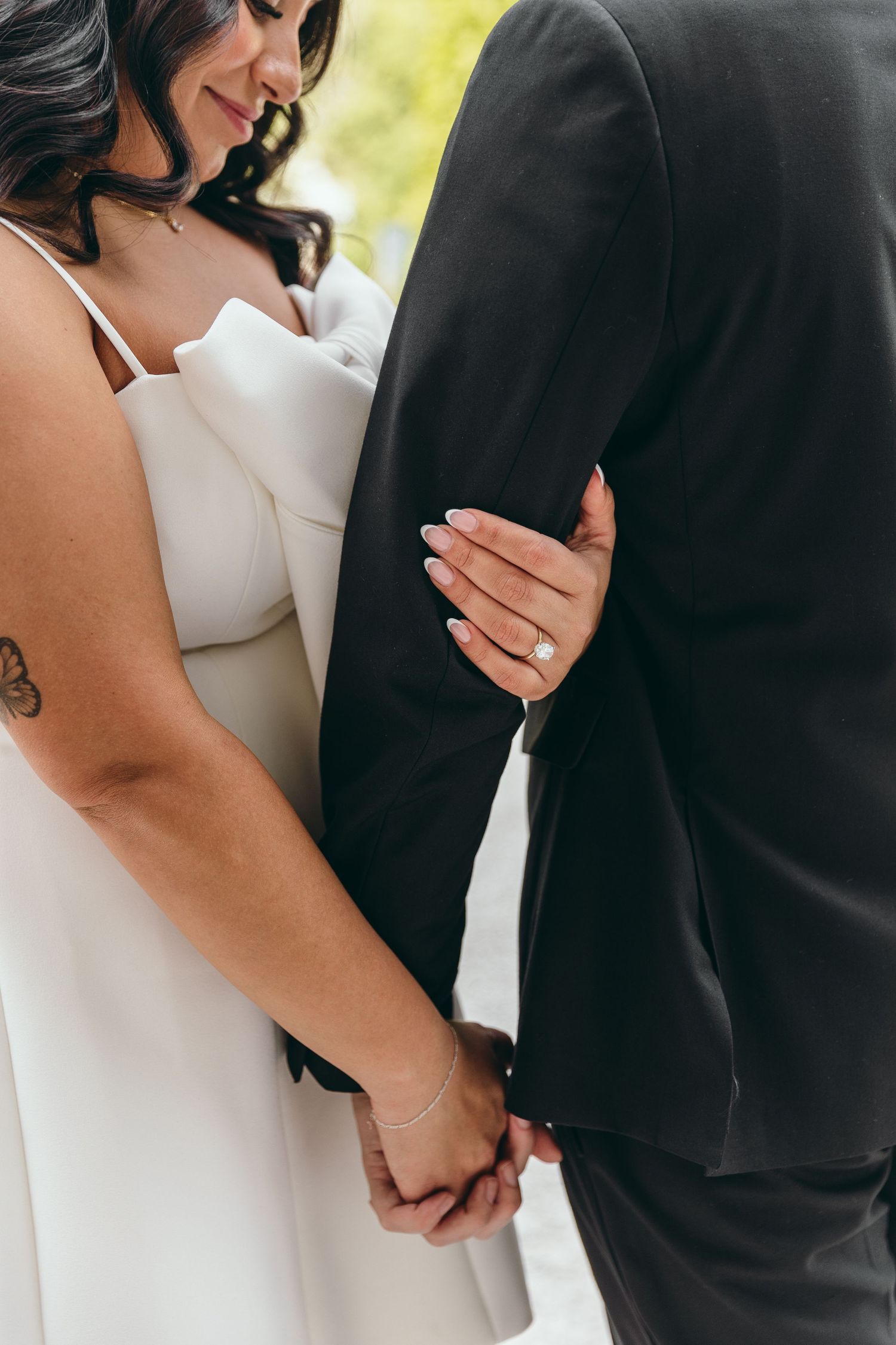 Close-up details of couple holding hands during intimate moment.