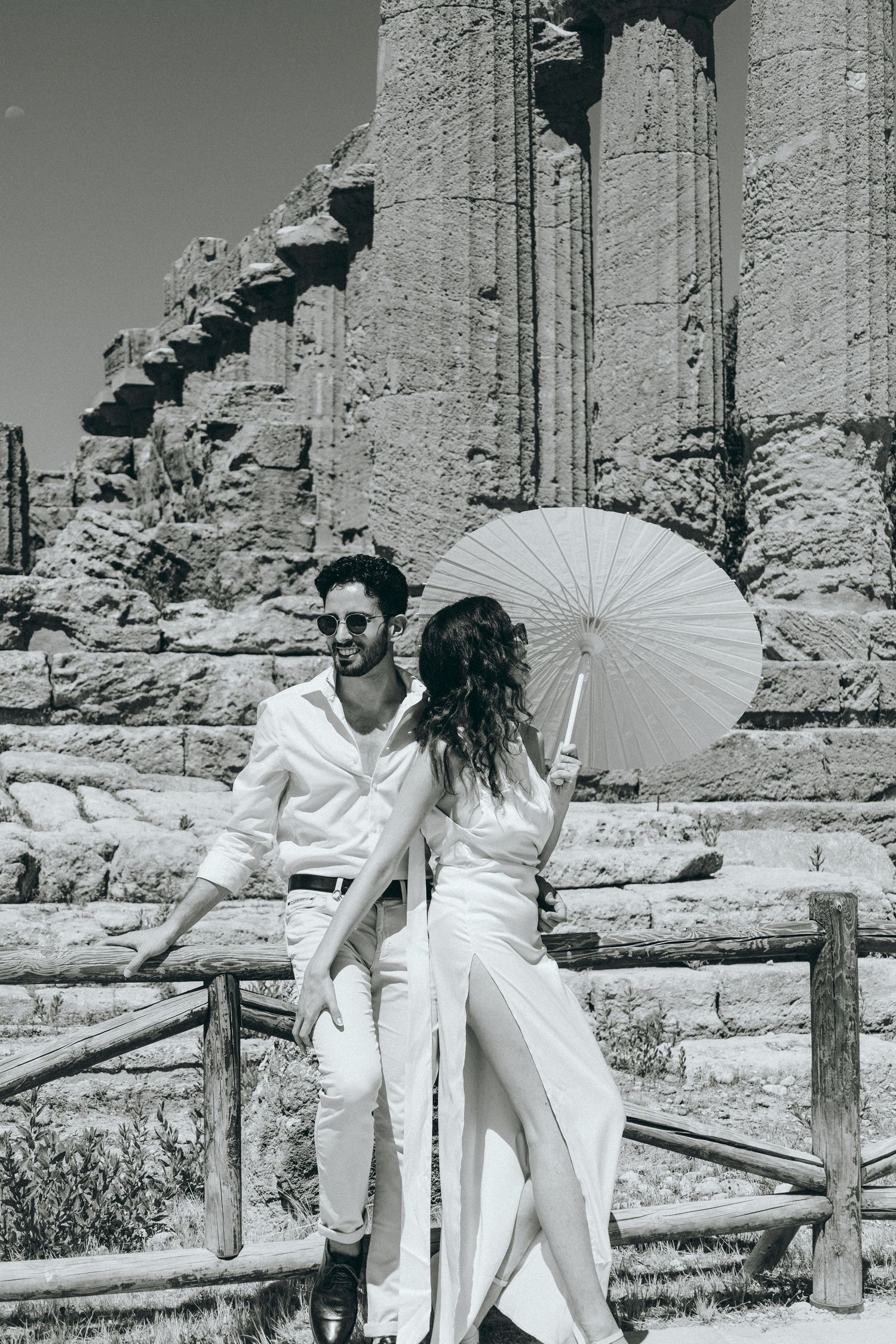 Artistic black and white photography session at historic temple ruins with parasol.