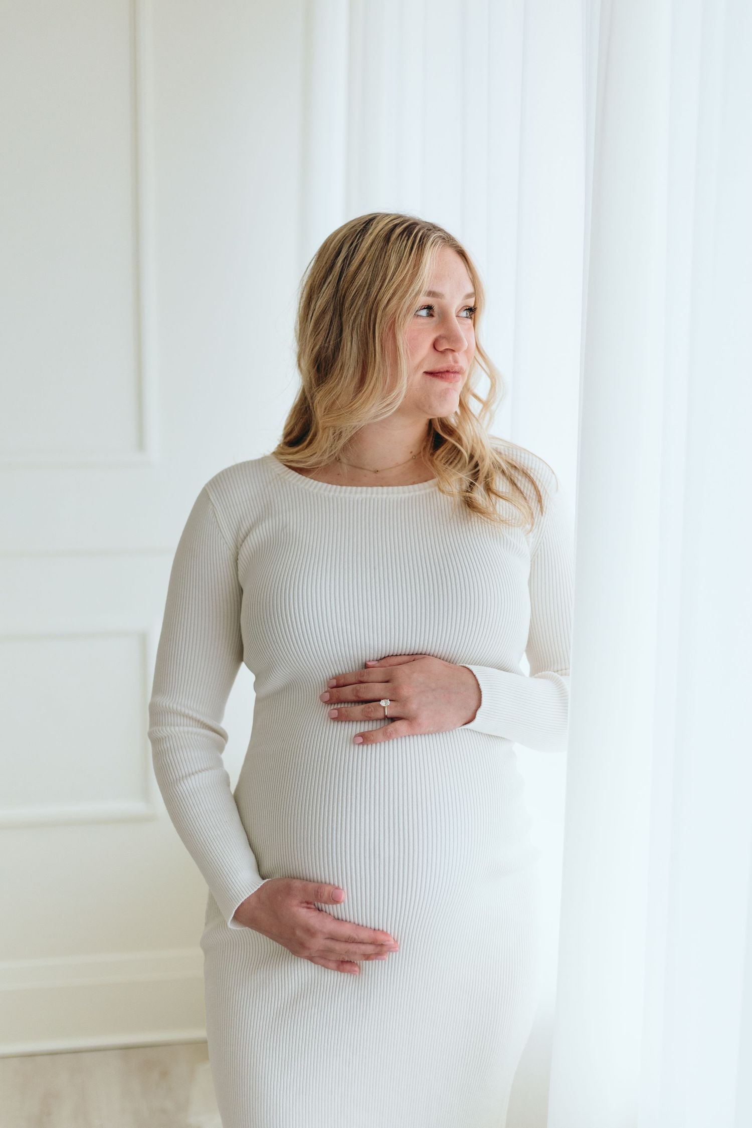 Maternity photos in white ribbed sweater showing different angles of pregnancy.