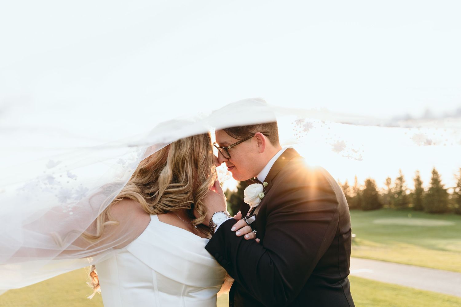 Warm sunlight bathes a wedding couple during their outdoor portrait session.