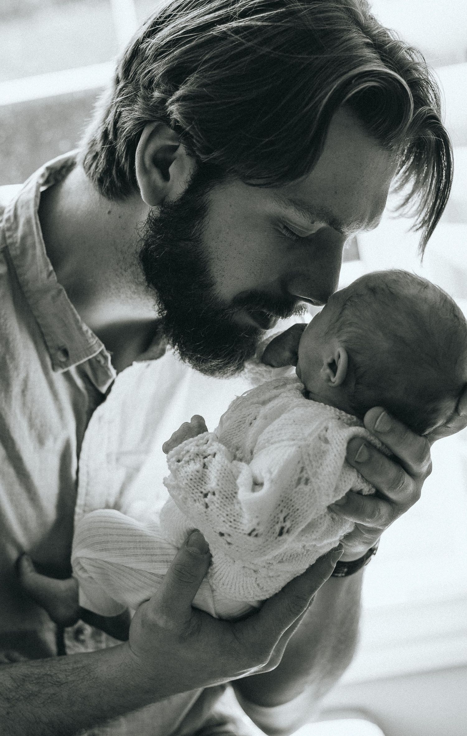 Black and white photo sequence showing tender moments between parent and infant.