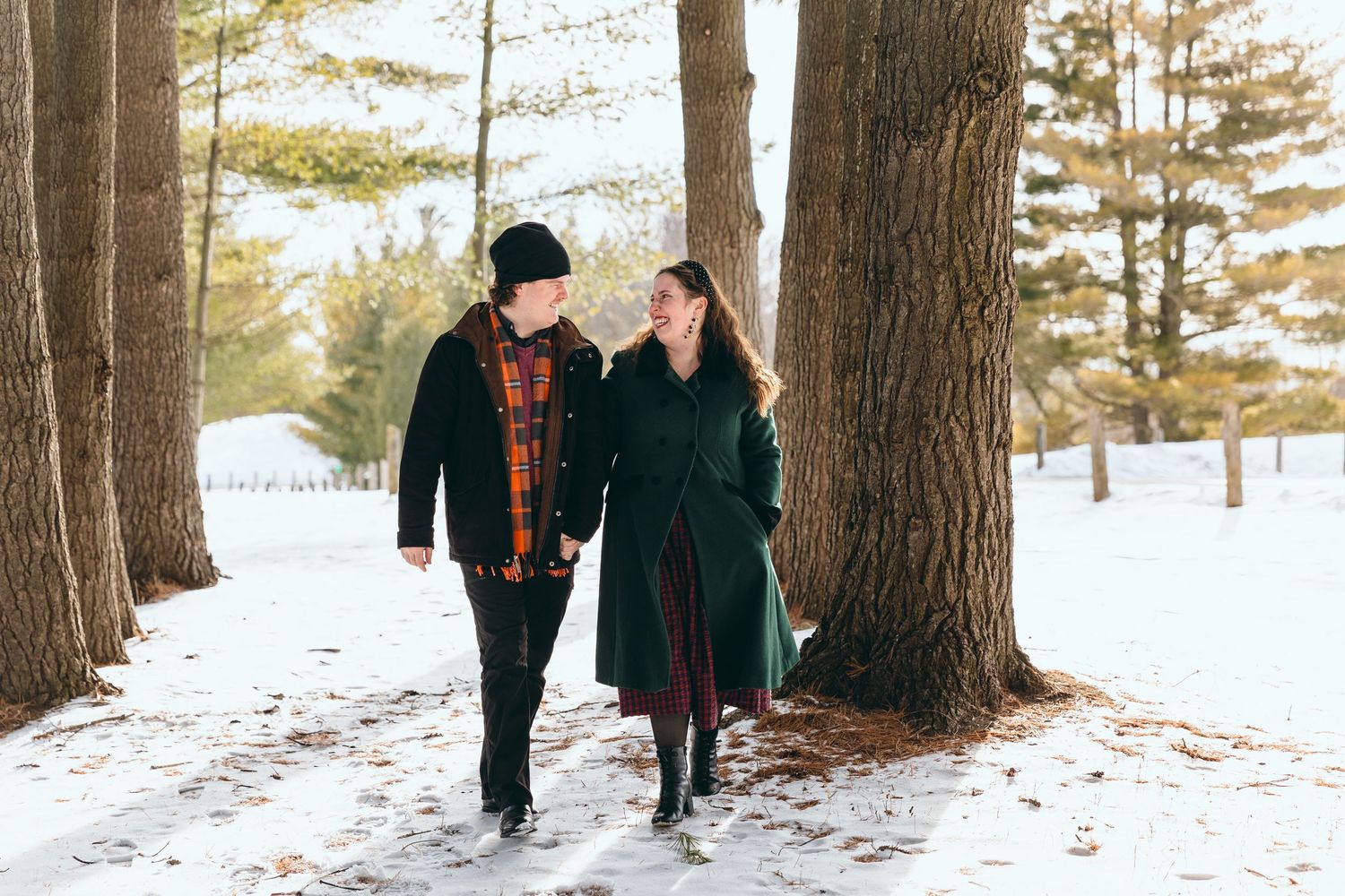 Winter engagement photos among snow-covered pine trees.